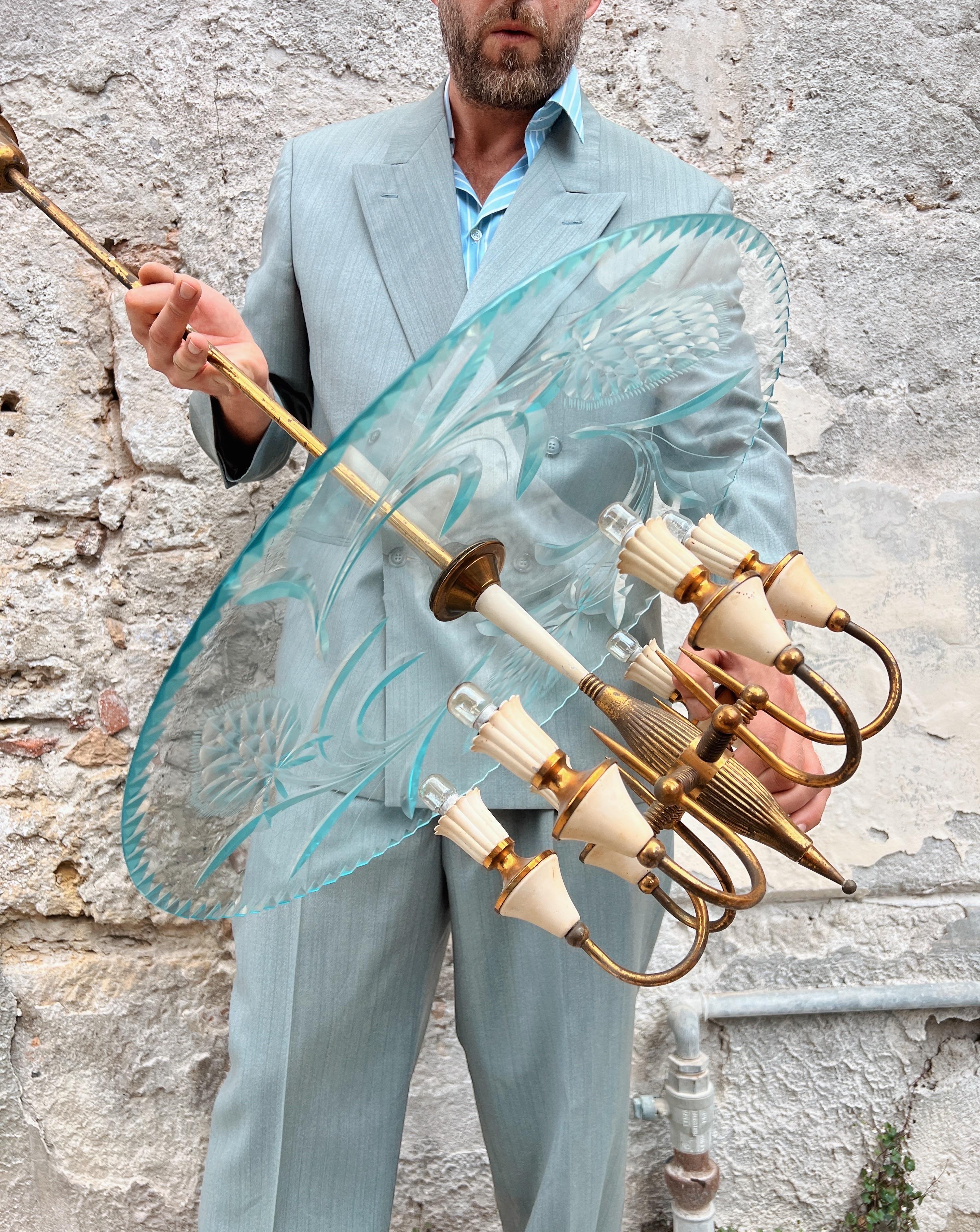 Introducing an exquisite Italian midcentury chandelier, designed by the iconic Pietro Chiesa, a true masterpiece of artistry.

This elegant and sober chandelier showcases stunning carved decorations on its glass, with a lovely hint of aquamarine
