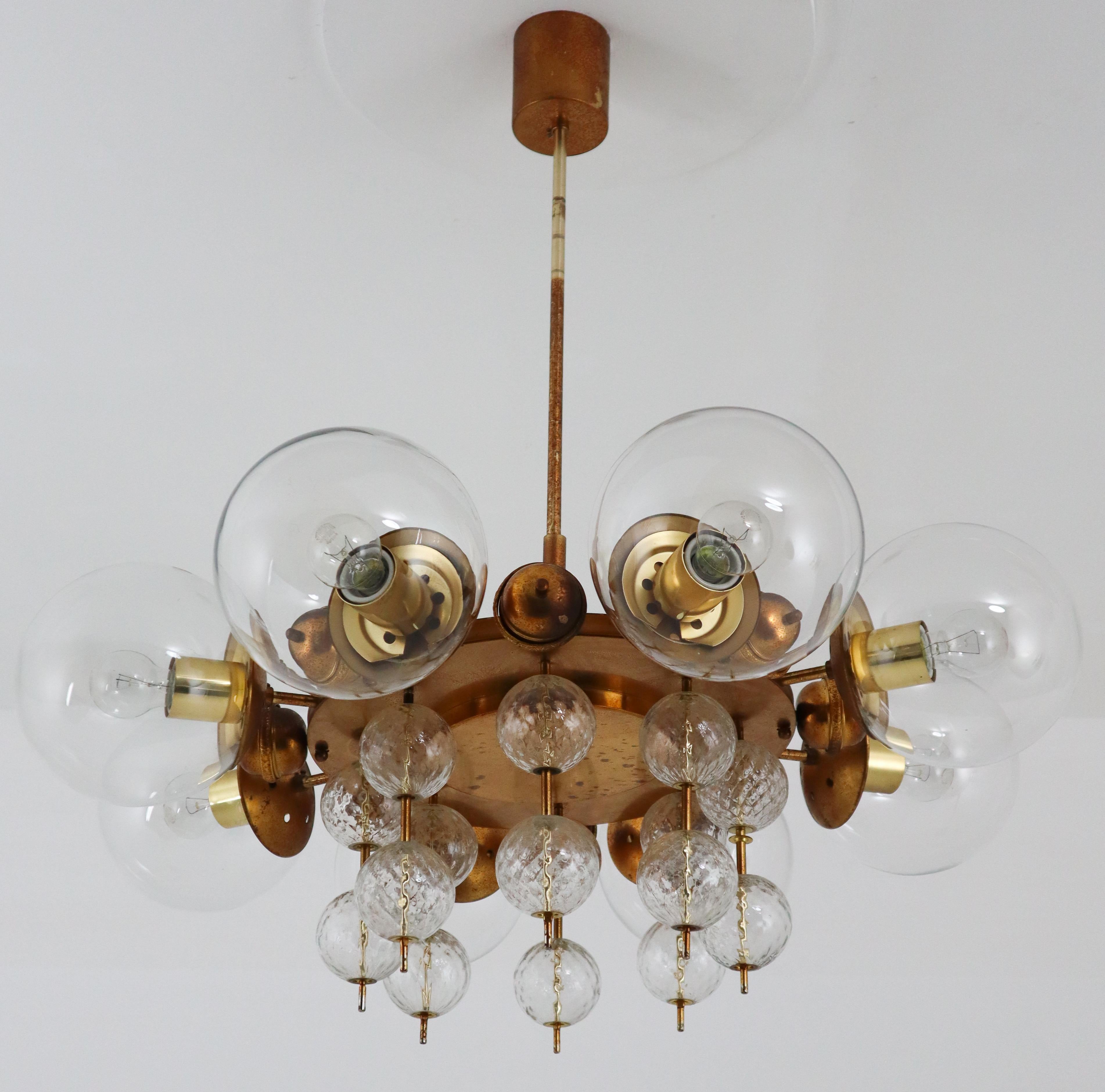 Midcentury chandelier with patinated brass fixture, Europe, 1950s

This patinated brass chandelier was produced in Europe in the 1950s. A spirited and chic design set chandeliers with brass fixture and hand blown glass. The chandelier with brass