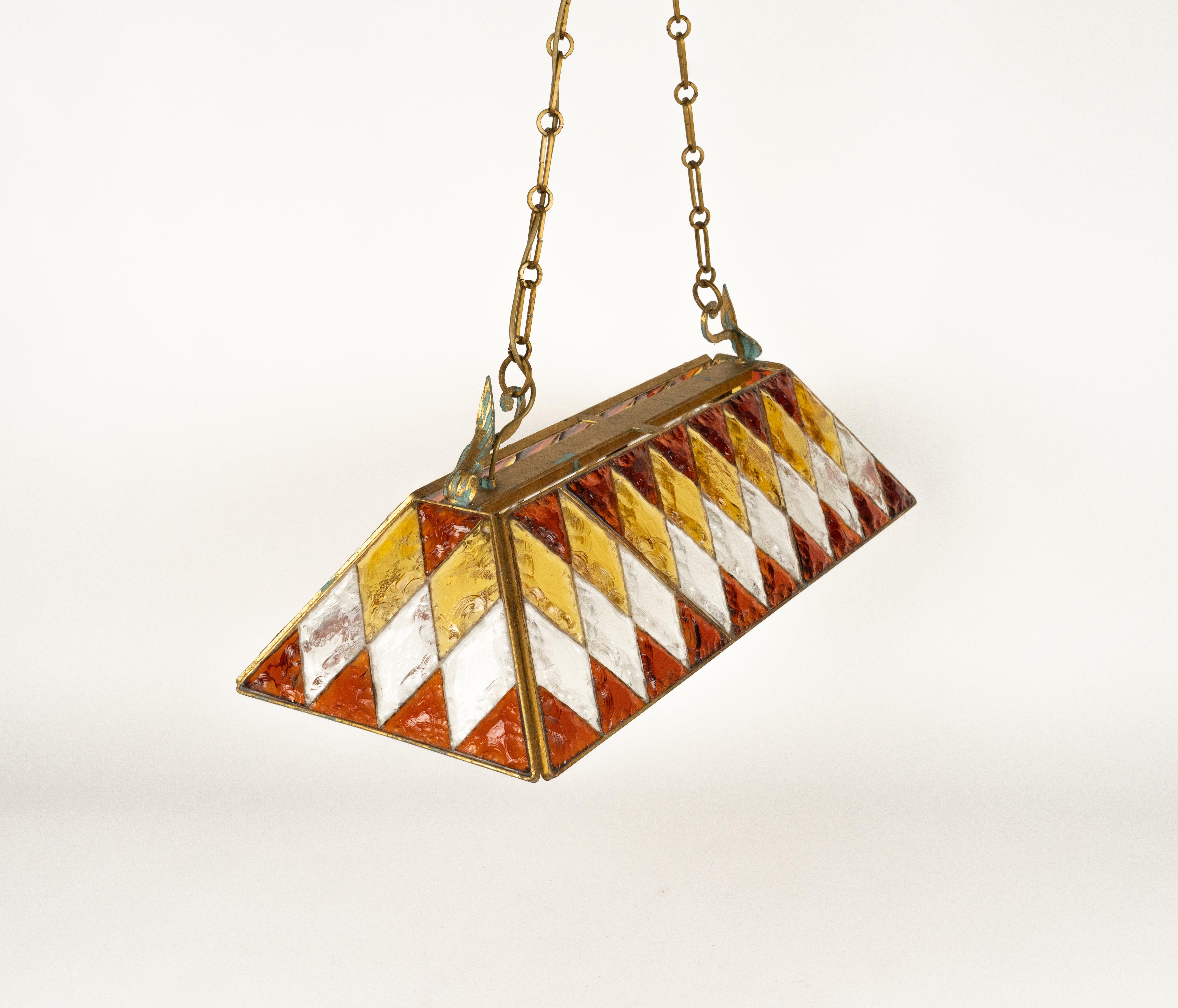 Midcentury amazing large chandelier in golden wrought iron and multi-color hammered glass produced by Longobard the concurrent of Poliarte at the 1960s / 1970s.

Made in Italy in the 1970s.

It uses 3 bulbs.