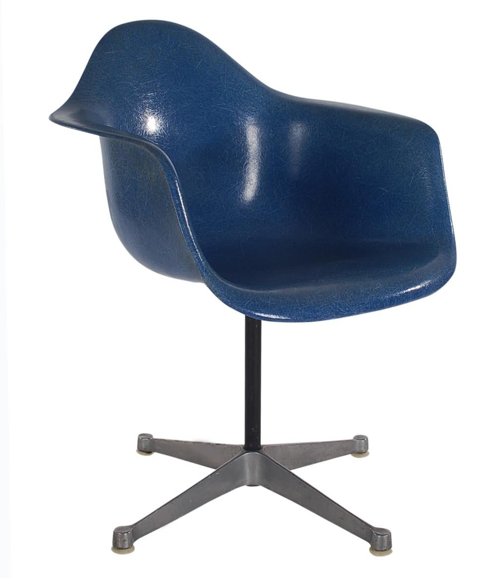 Here we have an iconic design Classic from the Mid-Century Modern period. This vintage fiberglass shell chair was designed by Charles Eames and produced by Herman Miller, circa 1972. These chairs are sold with their original swivel bases as shown.