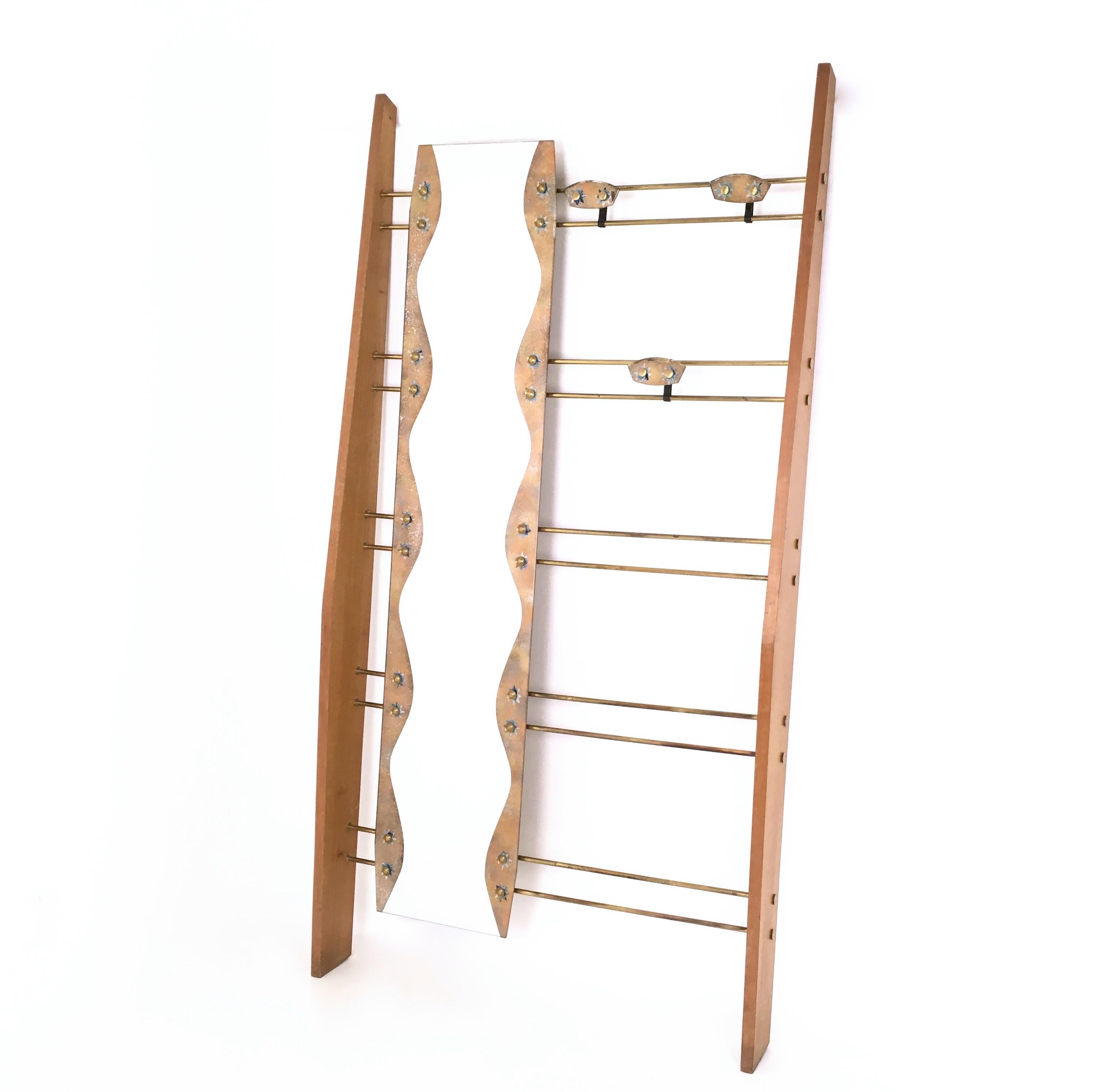 Made Italy, 1950s. 
This entryway coat rack is made in cherry veneer and features a brass frame, a mirror and painted brass and back-painted glass details.
It may show slight traces of use since it's vintage, but it can be considered as in good