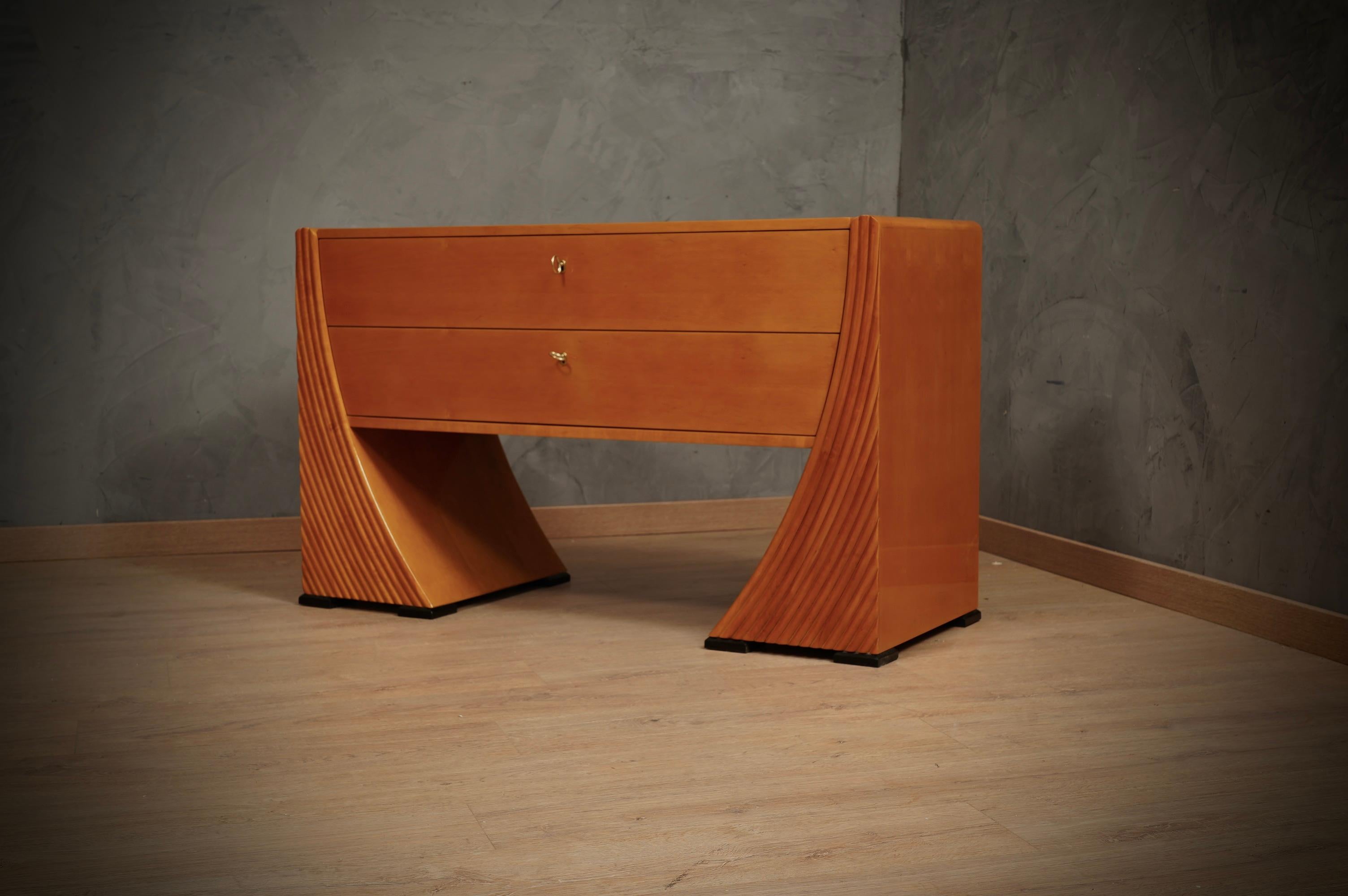 Raffinatezza e stile caratterizzano questa cassettiera, un design molto carismatico rende il comodino davvero elegante. In vero stile italiano di metà secolo.

La cassettiera è interamente impiallacciata in legno di ciliegio; il corpo ha due grandi