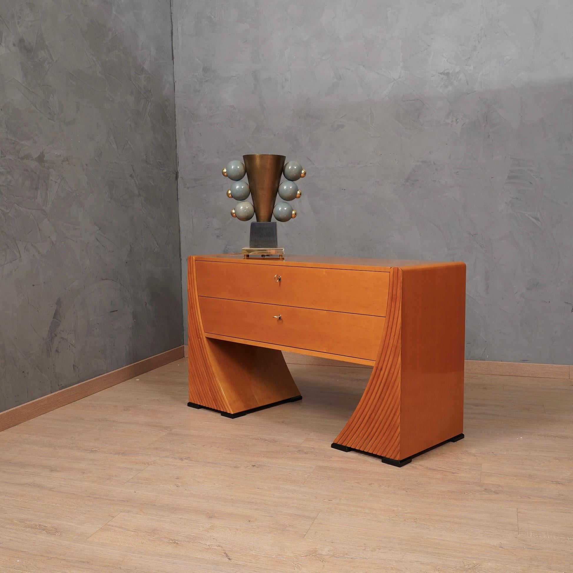 Raffinatezza e stile caratterizzano questa cassettiera, un design molto carismatico rende il comodino davvero elegante. In vero stile italiano di metà secolo.

La cassettiera è interamente impiallacciata in legno di ciliegio; il corpo ha due grandi