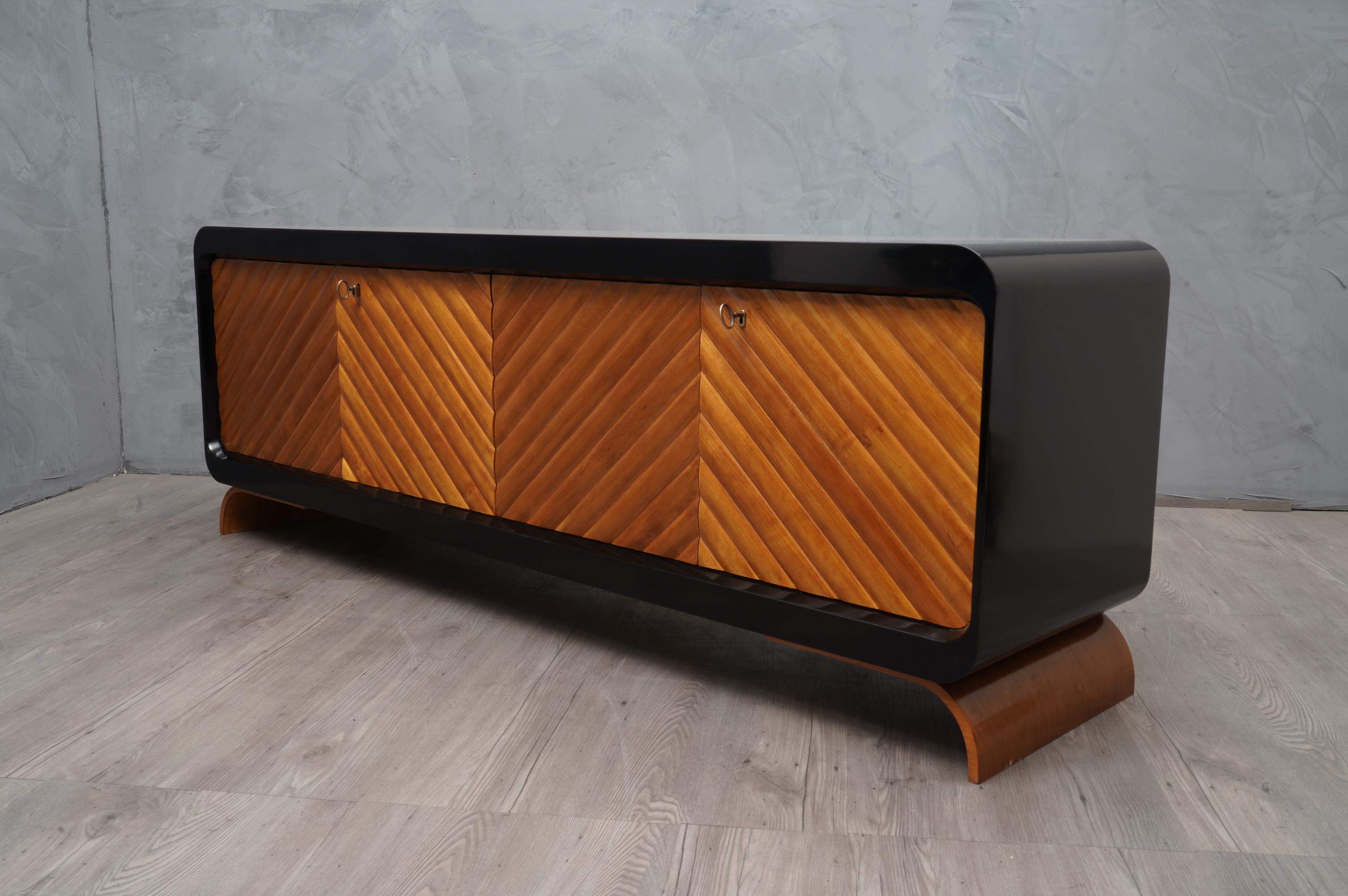 Special design with very pronounced rounded shapes with doors that form a herringbone pattern. Precious materials.

The sideboard has a smooth and well-polished black top, this does not end like a normal straight sideboard with an edge but continues