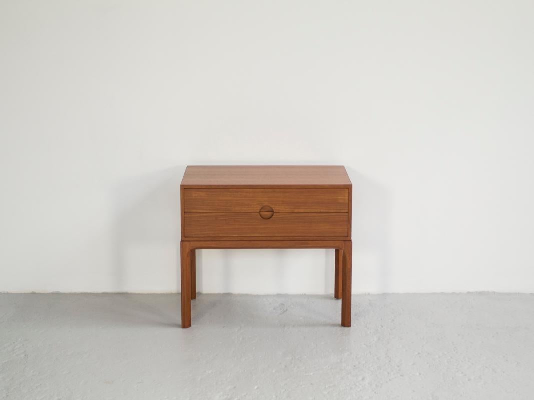This midcentury Danish chest of 2 drawers in teak was designed by Kai Kristiansen and manufactured by Aksel Kjersgaard in Denmark in the 1960s. It has a very beautiful design with the typical shape of the drawer handles. It was made with the best