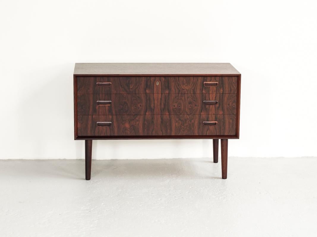 This midcentury Danish chest of 3 drawers in rosewood was designed by Kai Kristiansen and manufactured by FM Møbler in Denmark in the 1960s. It has beautiful drawings in the wood and is refined in every detail. This chest is in rosewood and in very