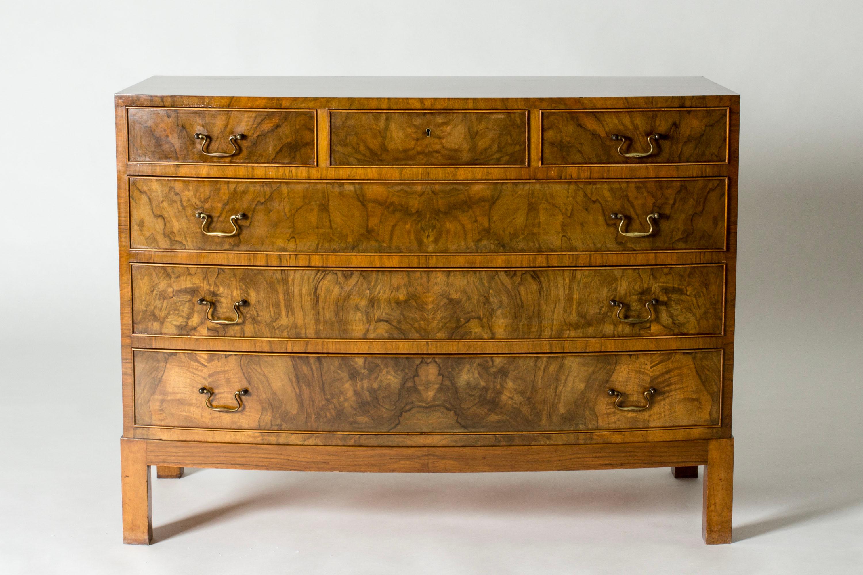 Élégante commode en noyer d'Ole Wanscher avec une façade en placage et des poignées en laiton. L'attention portée aux détails est remarquable.