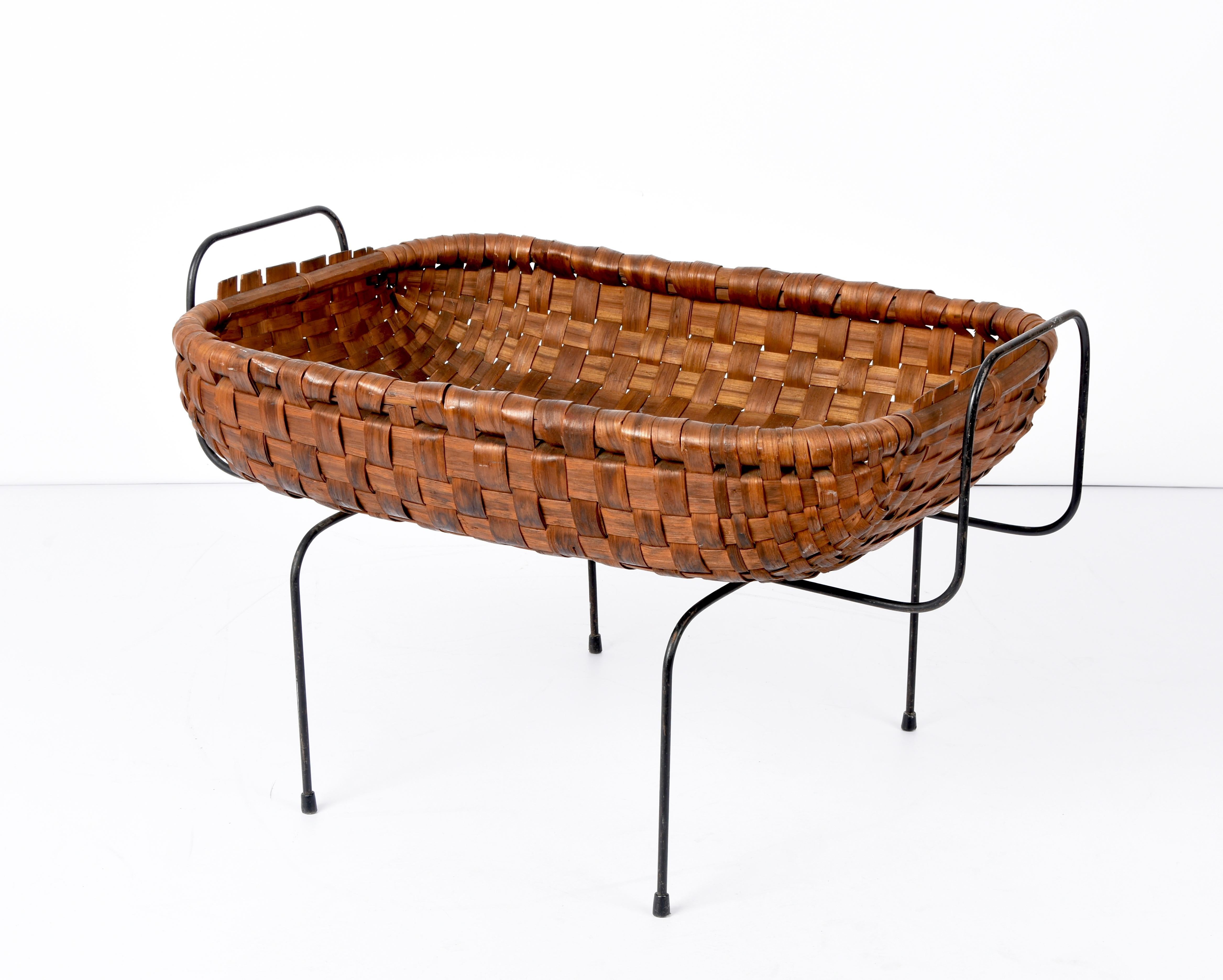 Unique mid-century chestnut wood, black metal and brass magazine basket. This amazing piece was made in Italy during the 1960s.

This piece is stunning as it has a black metal base, a fantastic interweaved chestnut wood basket and elegant brass