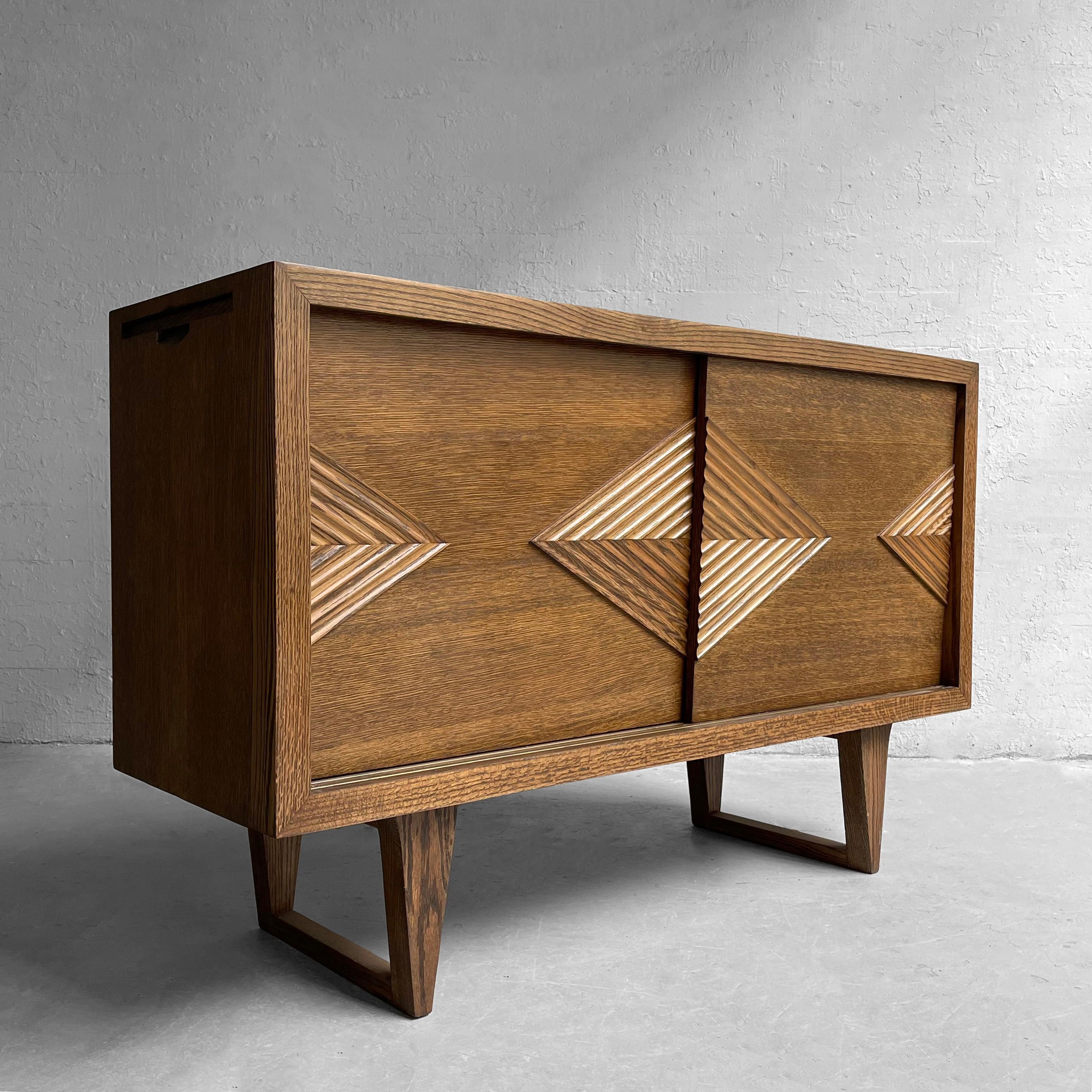 Mid-Century Modern, oak sideboard, credenza features superb design and craftsmanship with decoratively carved, diamond shape chevron doors that slide open to reveal multiple pull-out drawers and pull-out ledges on either side to extend the top
