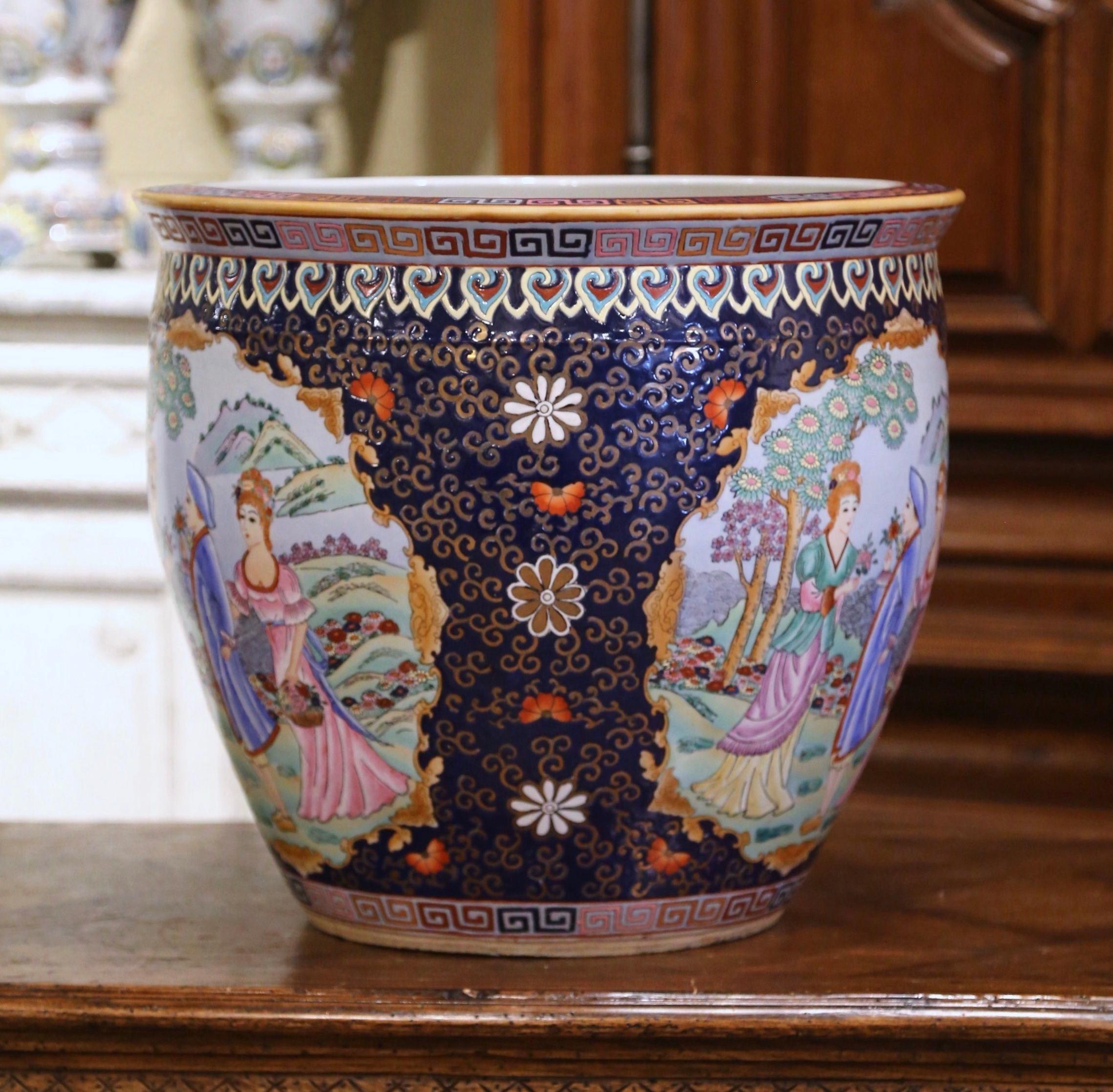 This elegant, colorful, vintage fishbowl was created in China, circa 1960. Round in shape, the large, mid-century porcelain bowl with Greek key border, features Classic oriental scenes with western style figural reserves and foliate motifs. The