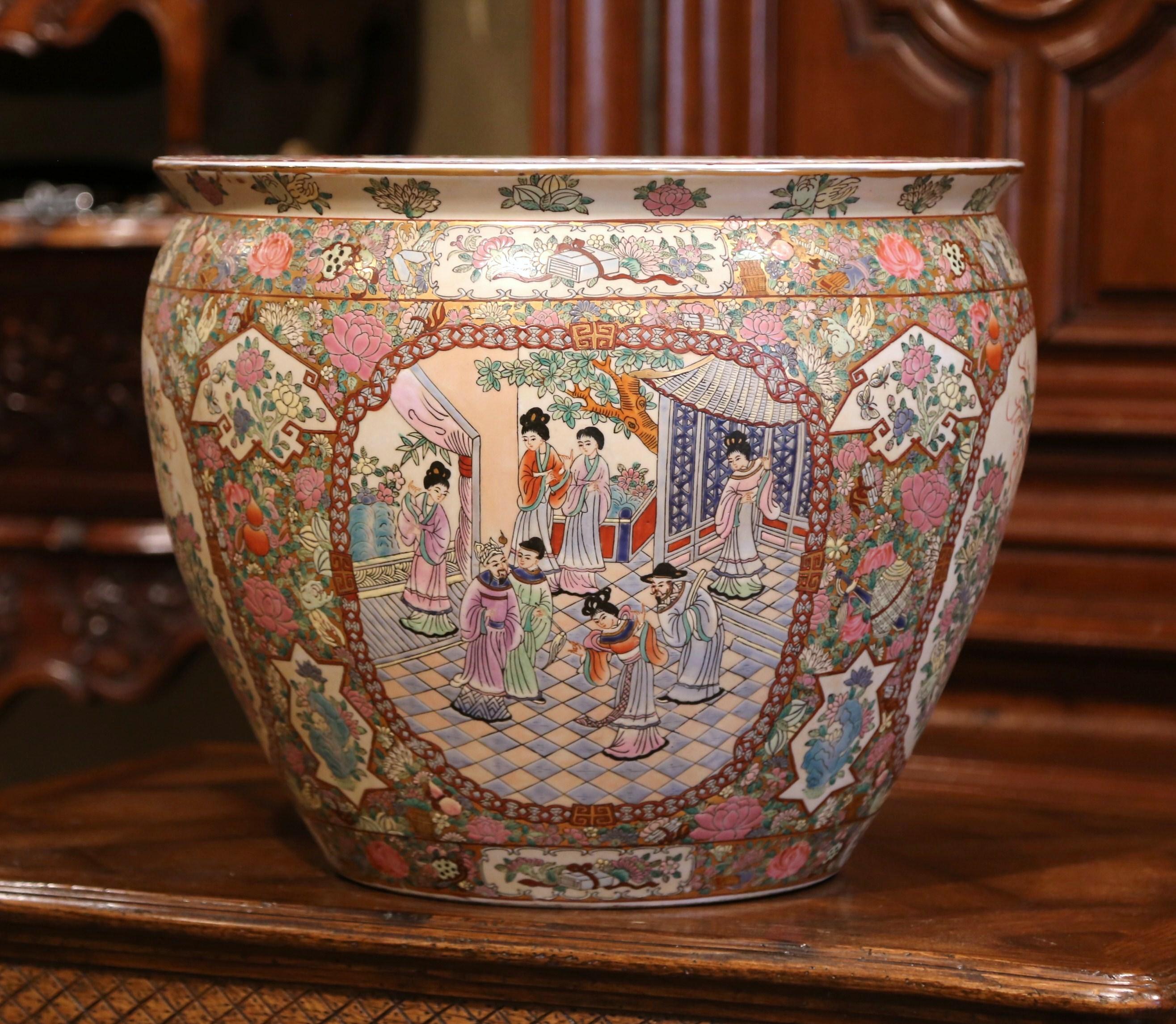 This elegant, colorful, vintage fishbowl was created in China, circa 1960. Round in shape, the large, midcentury porcelain bowl features Classic oriental scenes with Chinese people throughout. The ceramic vase is painted on the inside as well with a