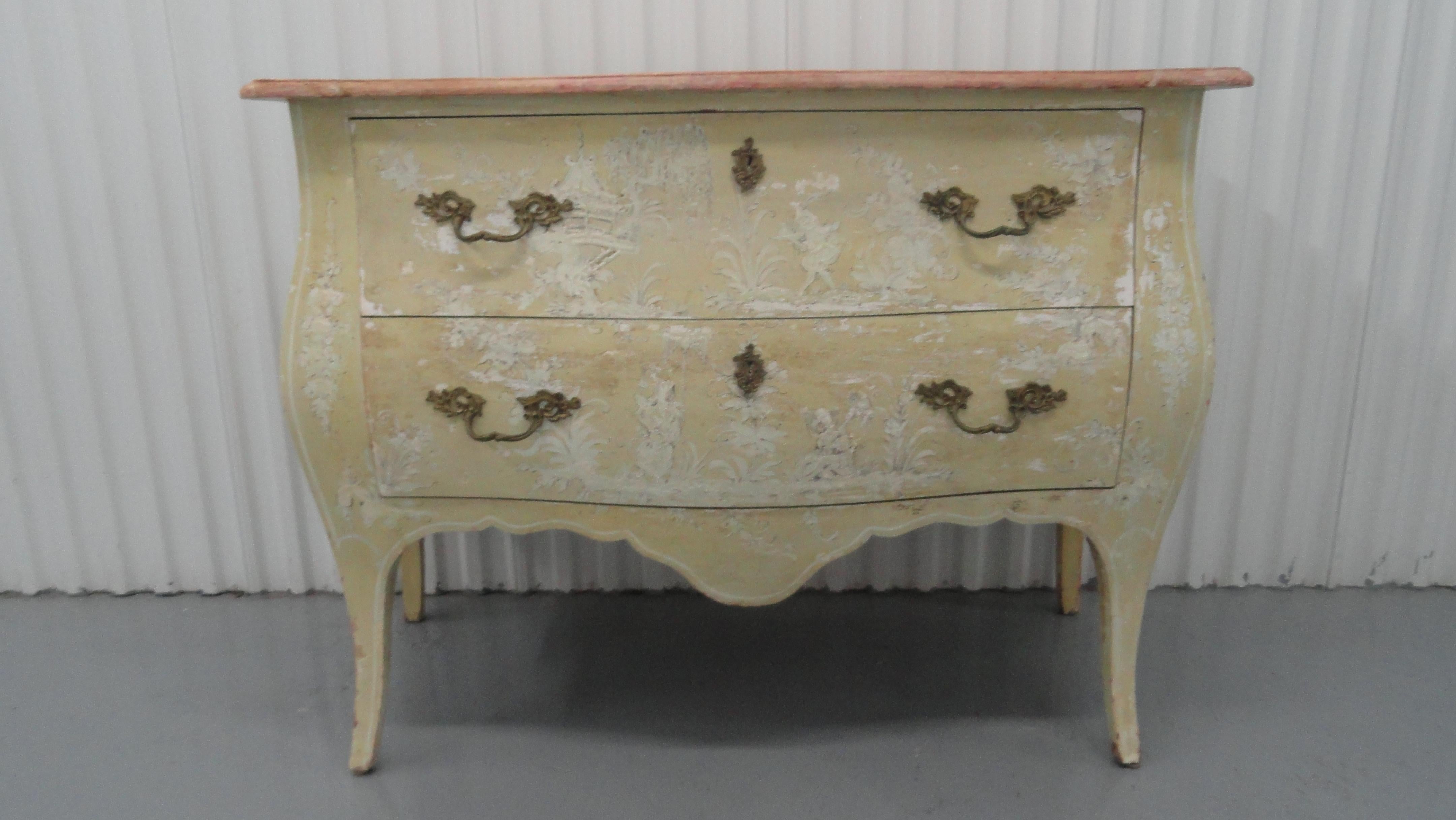 Fantasy painted Chinoiserie two-drawer bombe chest. Classic French bombe shape on this midcentury chest. Original hardware. Paintings are white and gray on an almond background. Beautiful age and patinazation.
The top is a trompe-l'oeil fantasy