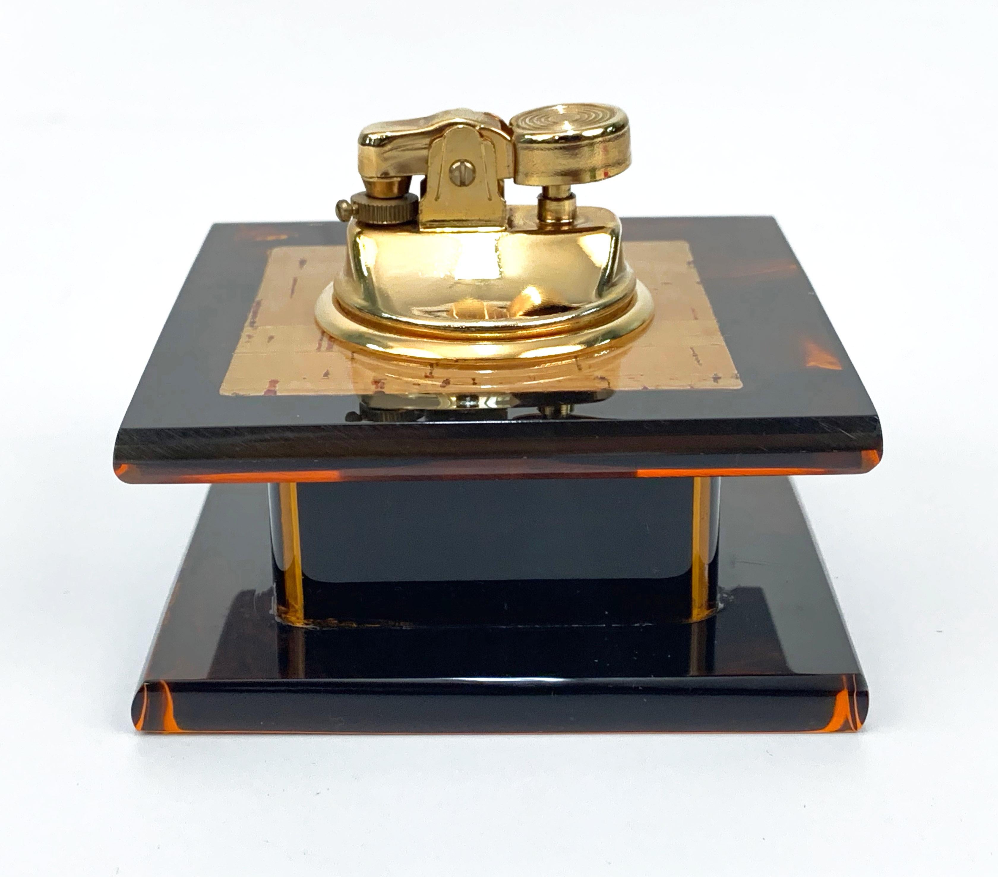 Magnificent table lighter in Lucite, tortoise plexiglass and brass in the style of Christian Dior, produced in France during 1970.

The never-ending charm of this piece is enhanced by being in perfect conditions, as this item has never been used.