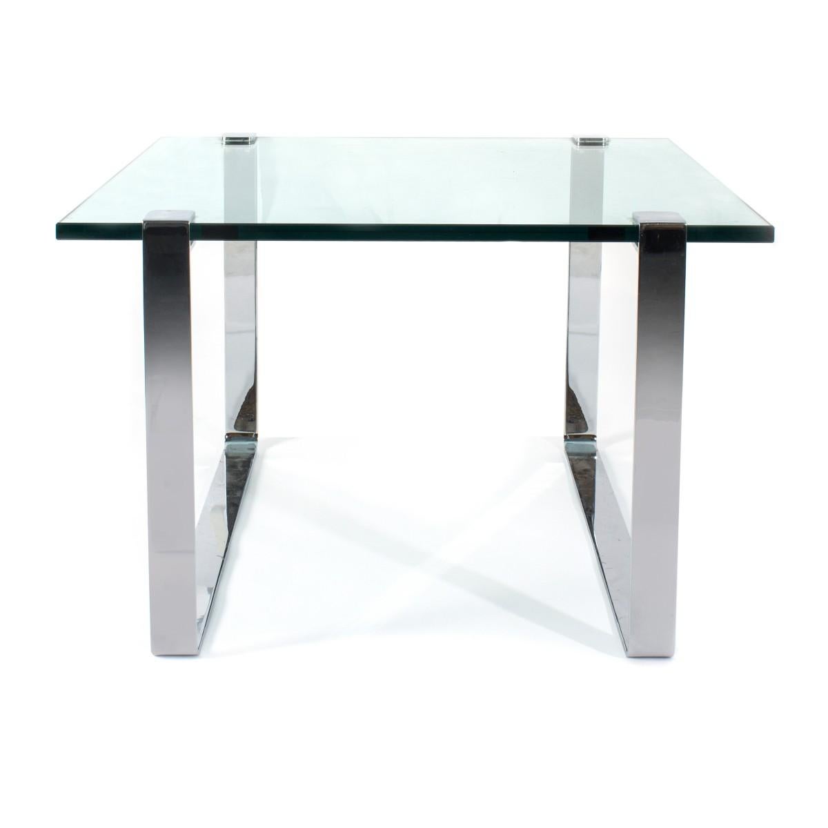1970s chrome and glass coffee or end table. This Mid-Century Modern table is unsigned but the quality of Brueton and the manner of Milo Baughman. The thick glass is held by two chrome bands.