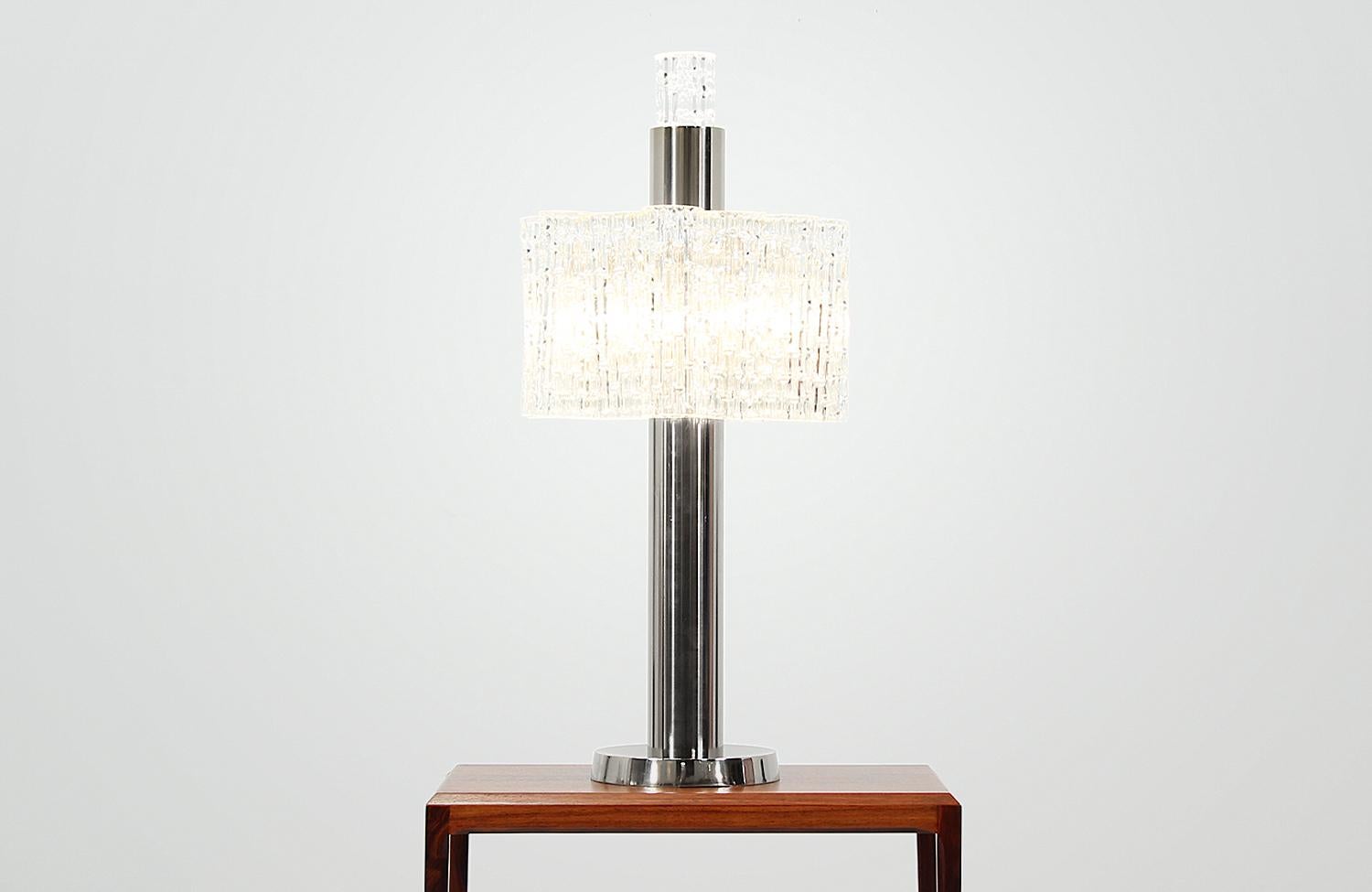 Schillernde Tischleuchte, entworfen und hergestellt von Doria Leuchten in Deutschland um 1960. Diese schöne Leuchte besteht aus fünfzehn strukturierten Murano-Glasröhren, von denen vierzehn um den verchromten Stahlrahmen hängen und eine Röhre in der