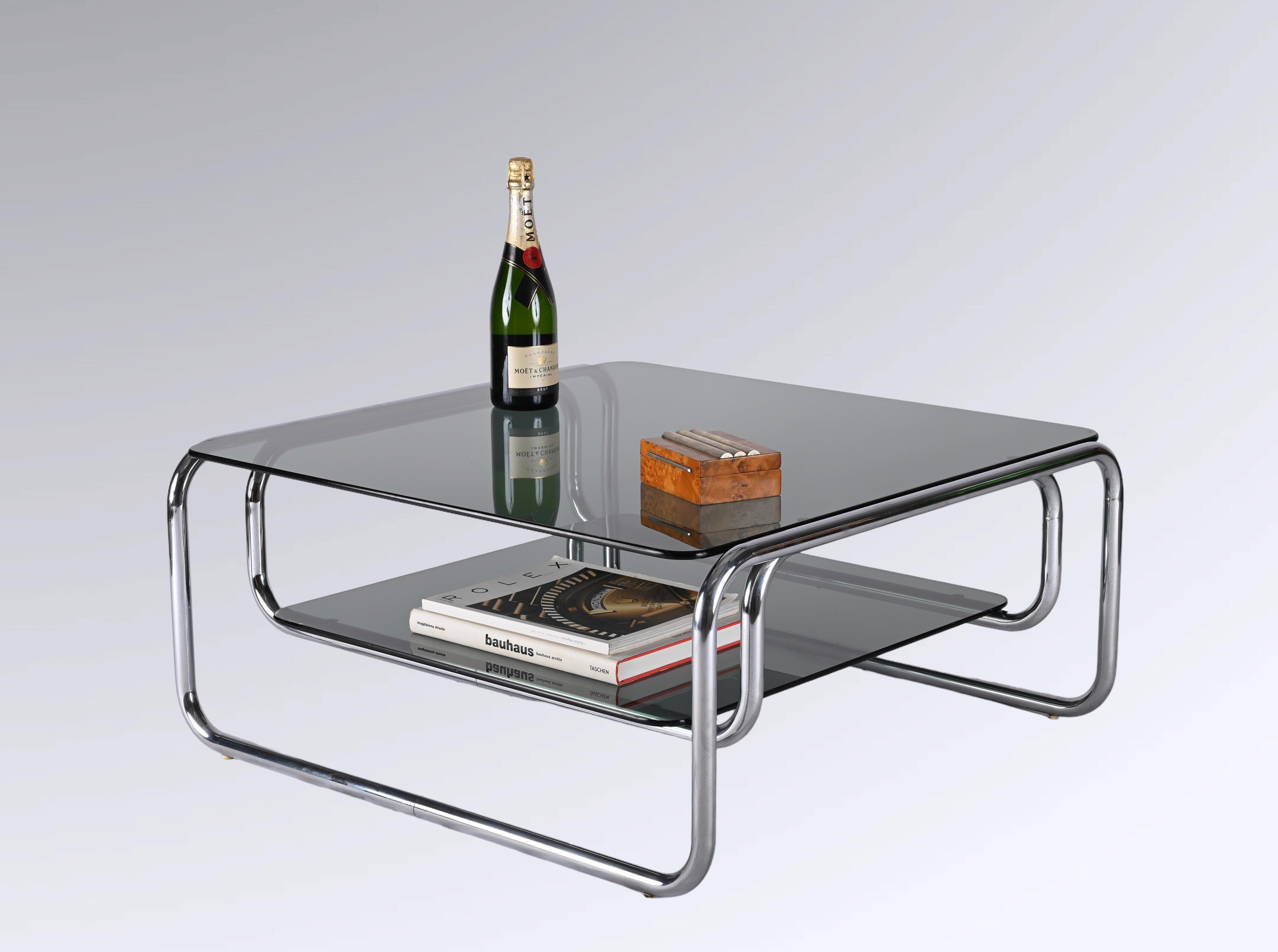 Astonishing double-tiered coffee table in chromed steel with thick smoked glasses. Gianfranco Frattini probably designed this fantastic piece in Italy during the 1970s.

The contrast between the straight lines of the smoked glasses and the curved