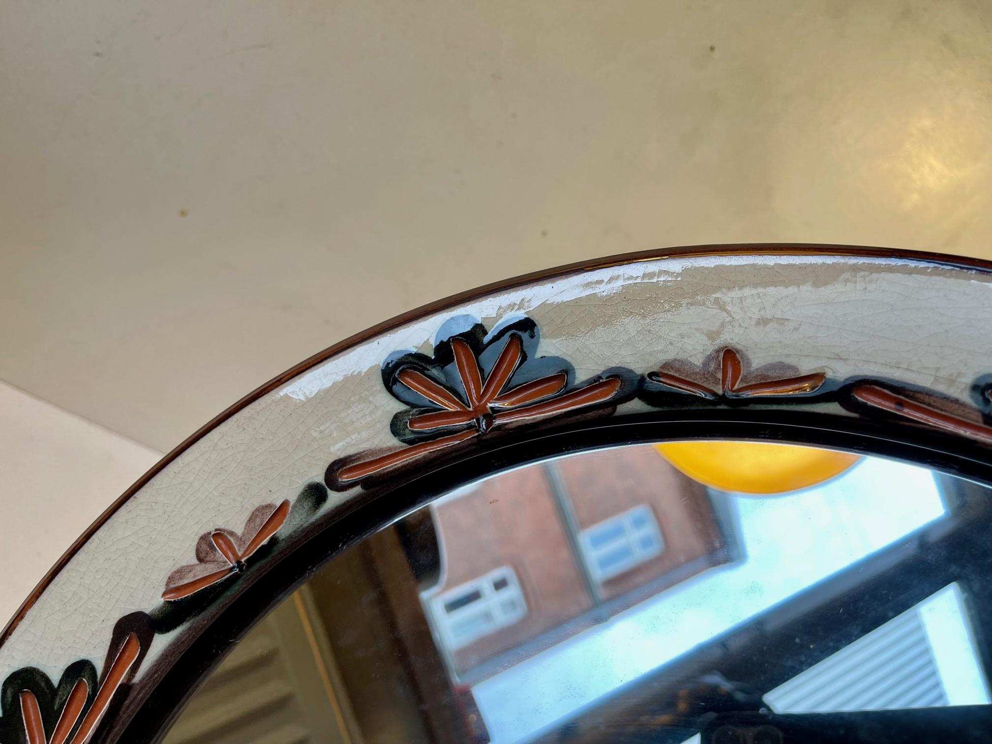 A piece unique studio wall mirror in glazed ceramic. Decorated with incised floral impressions. Designed and made by Zoltan Kiss for Knabstrup in Denmark in 1964. Its signed by hand by the ceramist to the backside. Measurements: Diameter: 43 cm,