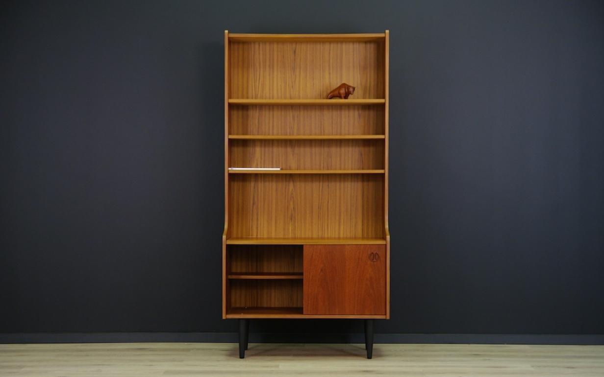 Original bookcase/cabinet from the 1960s-1970s. Spacious interior with boards behind the sliding doors. Veneered with teak. Dresser in good condition (small scratches and dings are visible).

Dimensions: height 177cm, width 88.5cm, top depth 26cm,