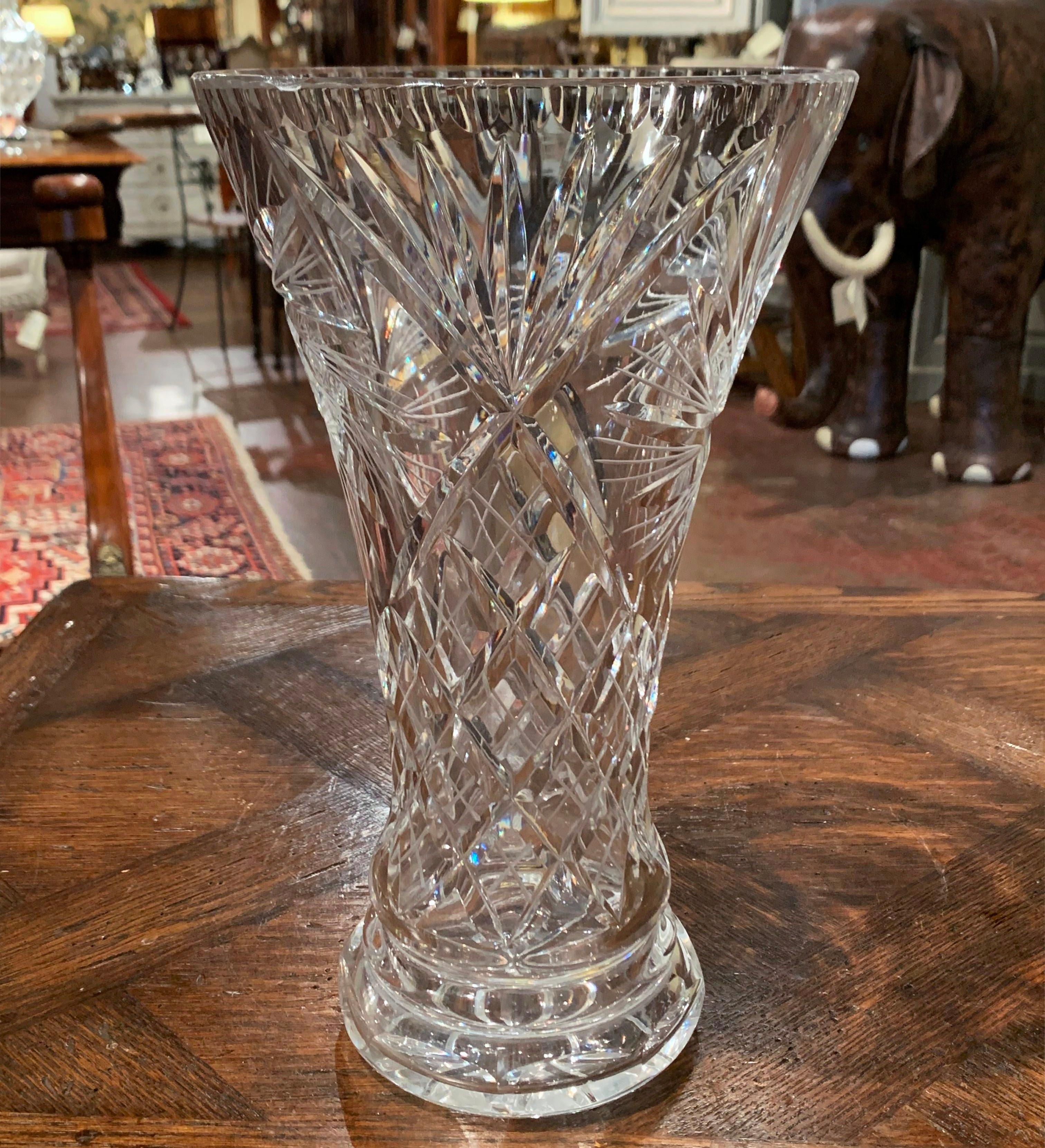Decorate a console or buffet with this elegant crystal trumpet vase. Crafted in France, circa 1960, the large luxurious cut glass vessel is decorated throughout with geometric, sun and star decor. The thick heavy flower vase is in excellent