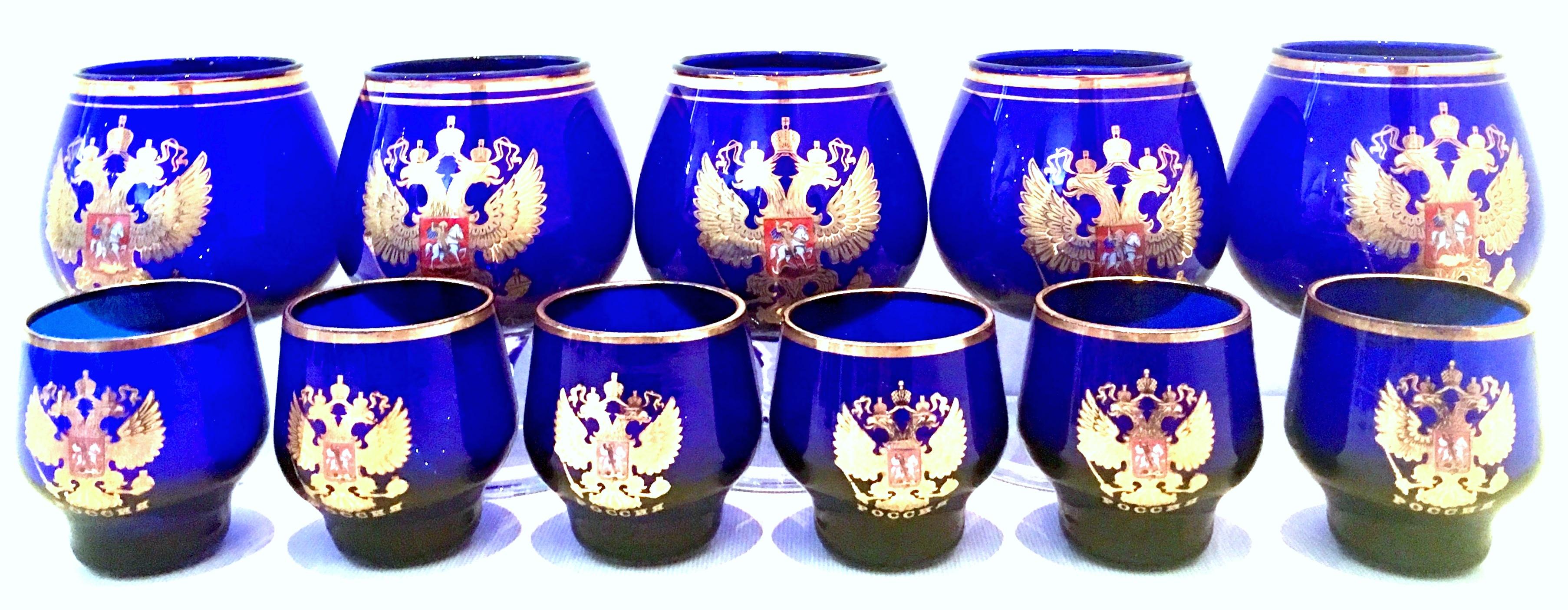 Mid-20th Century Cobalt & 22K Gold Coat Of Arms Bohemia Glass Drinks Set Of Eleven Pieces. Set includes, five brandy stem glasses and six rocks glasses.
Rocks Glass measures, 2.25