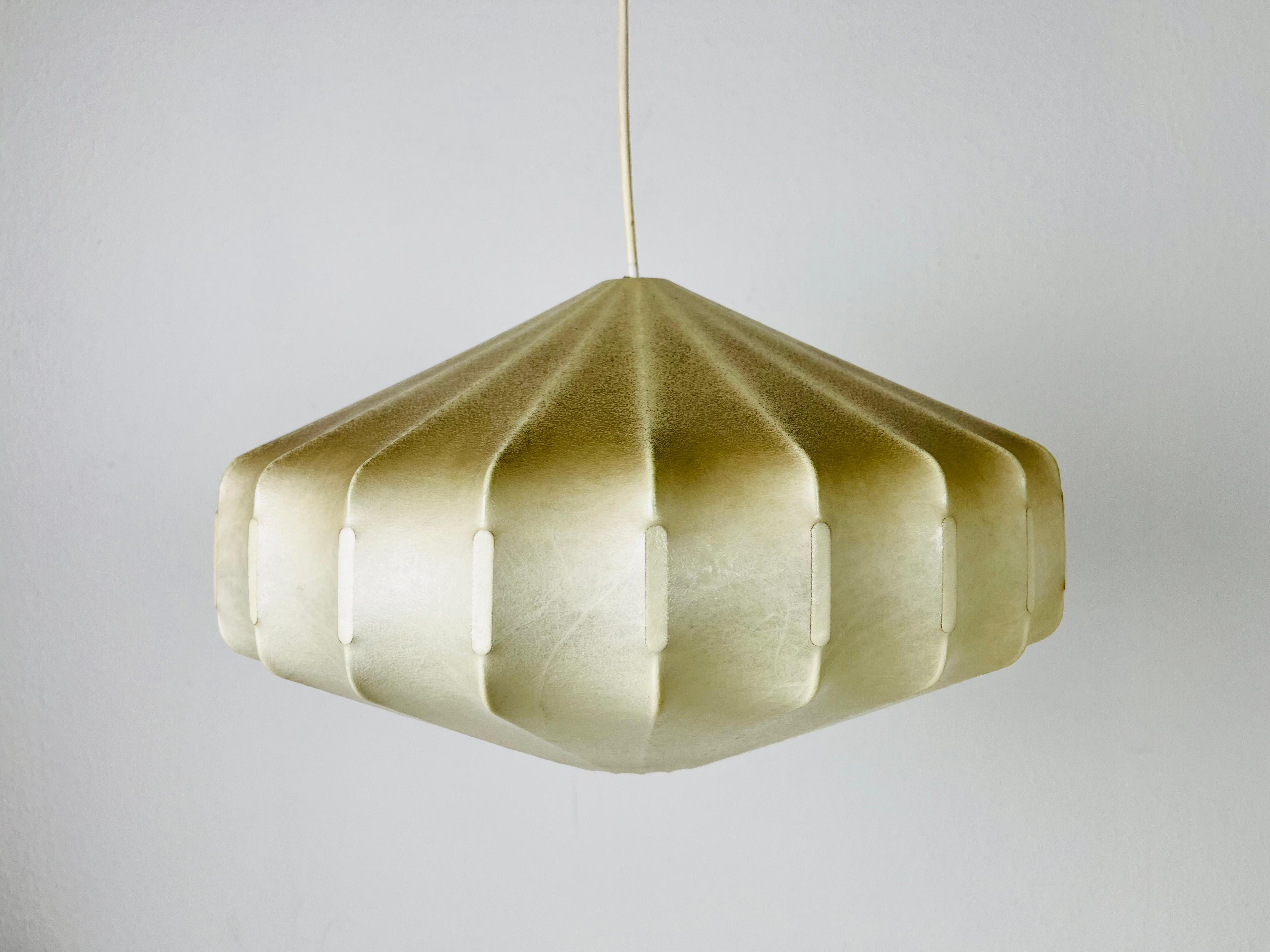 A cocoon pendant lamp made Friedel Wauer in Germany in the 1960s. The hanging lamp has a design similar to the lightings made by Achille Castiglioni. The lamp shade is made of original resin and has a losange shape.

Measurements:
Height: 25-70
