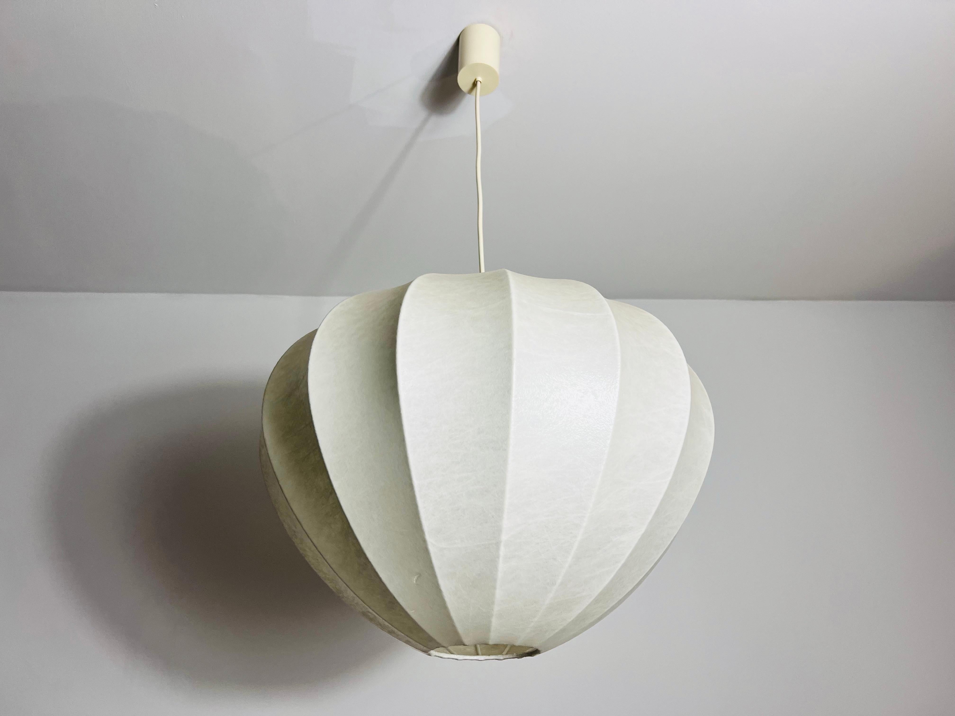 Una lampada a sospensione a bozzolo realizzata in Italia negli anni '60. Questa lampada a sospensione presenta un design che ricorda le iconiche creazioni di Achille Castiglioni, mostrando un mix di eleganza e modernità tipico di quell'epoca. Il
