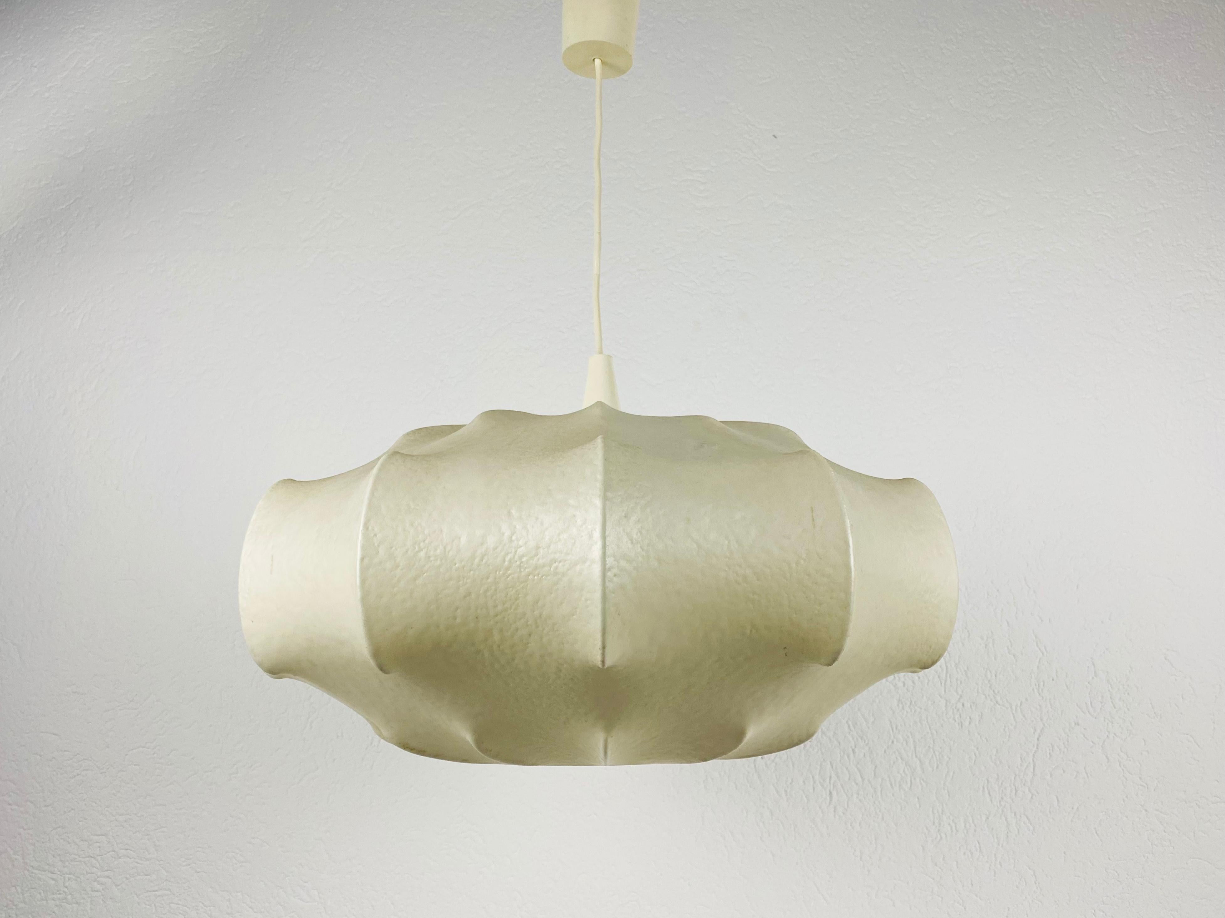 A cocoon pendant lamp made in Italy in the 1960s. The hanging lamp has a design similar to the lightings made by Achille Castiglioni. The lamp shade is of original resin and has a flower shape.

Measures: Height 25-70 cm 
Diameter 52 cm

The