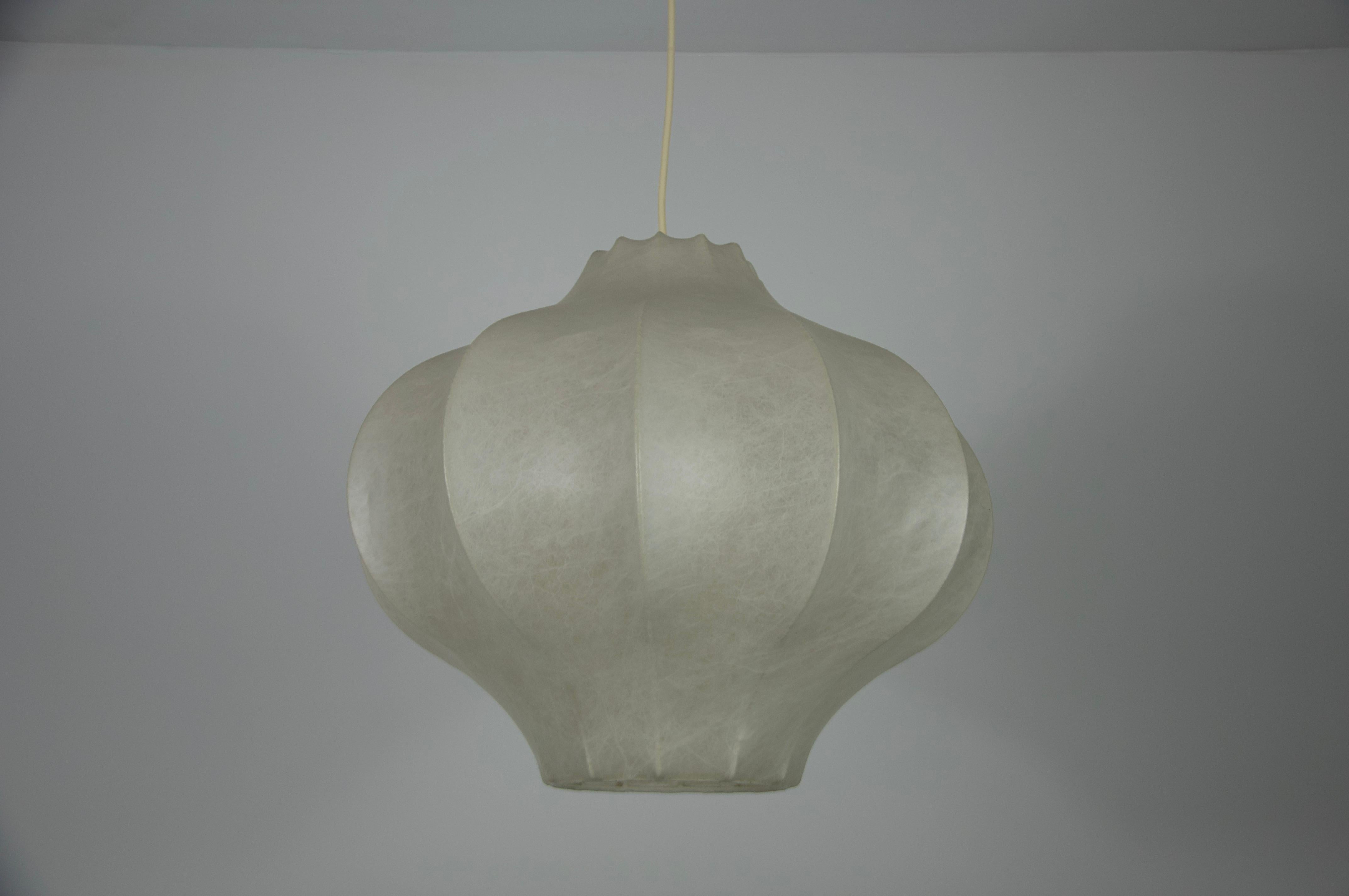This extraordinary cocoon pendant lamp, crafted in Italy during the 1960s, features a highly unusual and sculptural design that epitomizes the elegance of mid-century modern aesthetics. The flowing, organic shape creates a striking visual impact,