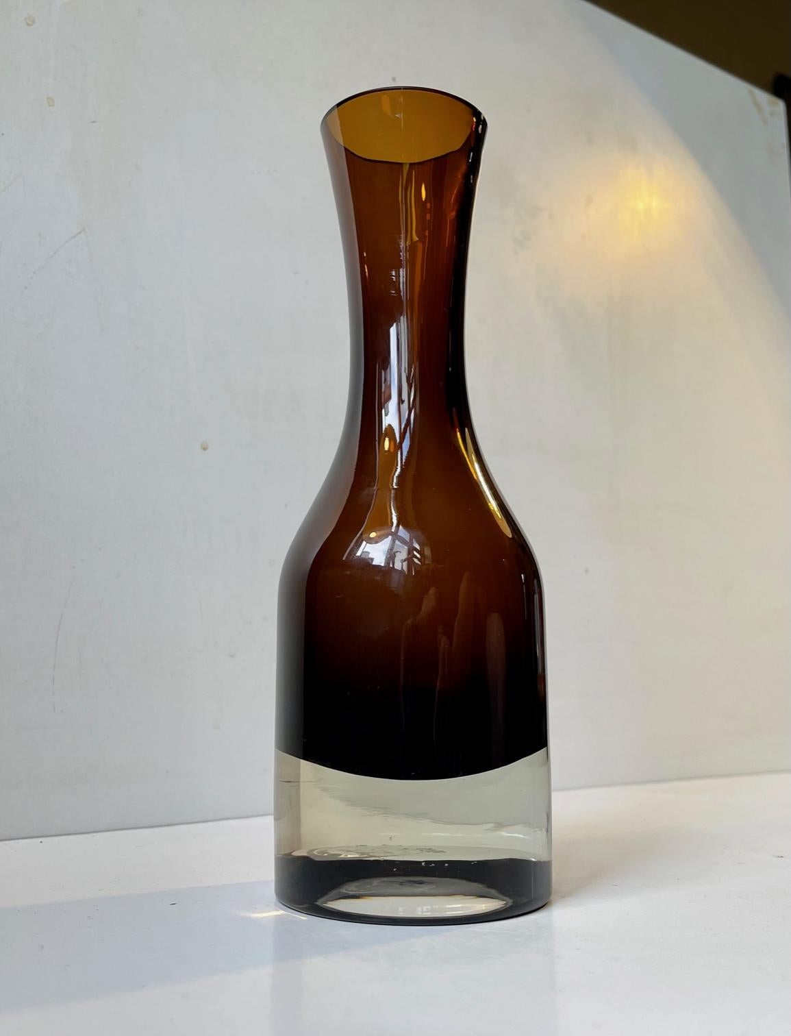 Coffee brown glass vase designed by either Tamara Aladin or Aimo Okkolin in 1970. Manufactured by Riihimaen Lasi in Finland. This is design number 1380. This piece is numbered and has a maker mark to the base. Measurements: Height: 24.5 cm,