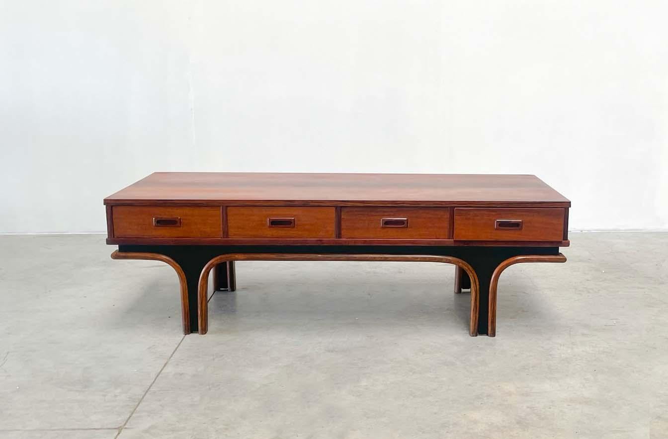 Beautiful coffee table designed by top Italian designer Giano Frattini. Frattini designed this table for the company Bernini. 

 

The table has a very nice rosewood. It consists of 4 drawers that you can open along 2 sides. Besides a beautiful