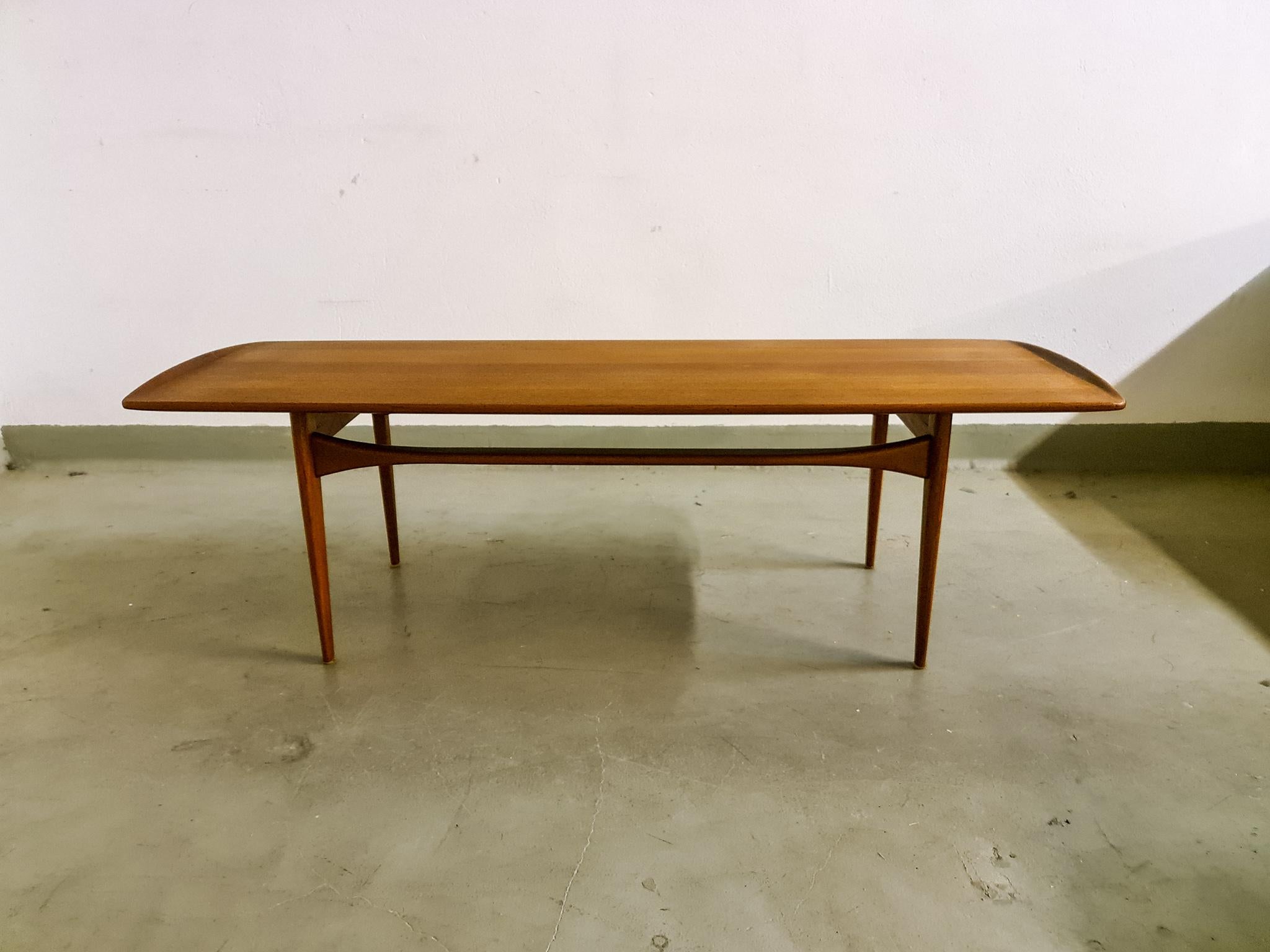 This teak coffee table with sleek lines and solid construction was manufactured in Denmark during the 1960s. Designed by Tove & Edvard Kindt Larsen and manufactured at France and Daverkosen this a great example of the simplicity and elegance that