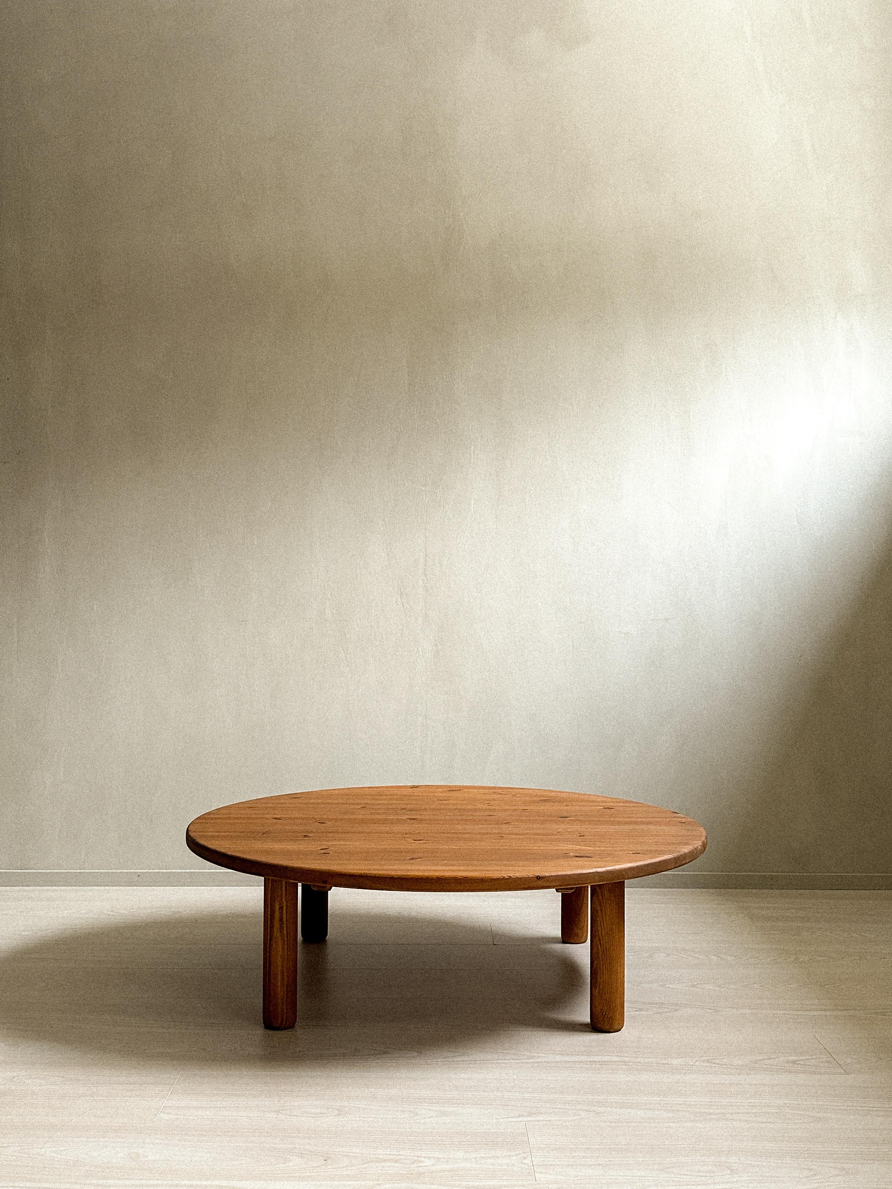 This Scandinavian midcentury coffee table from around 1960s, inspired by Charlotte Perriand, features a brown stained color and is crafted from solid pine. Its four rounded legs add a unique touch of elegance to the design.