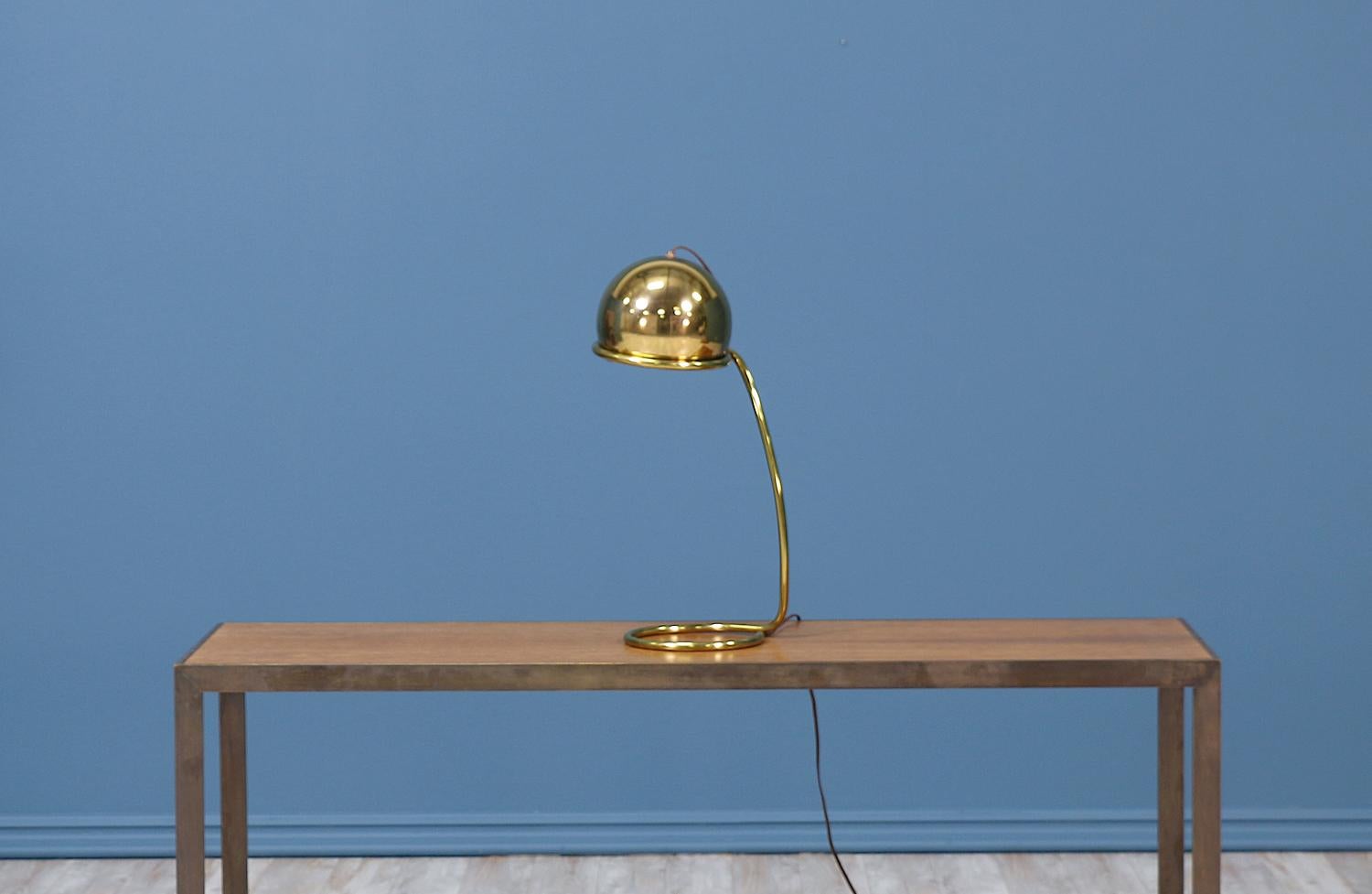 Midcentury desk lamp designed and manufactured circa 1960s in the United States. A mixture of coiled and curved lines support the geometric dome shade. This brass beauty has been re-polished and displays an age appropriate patina.

ID number:
