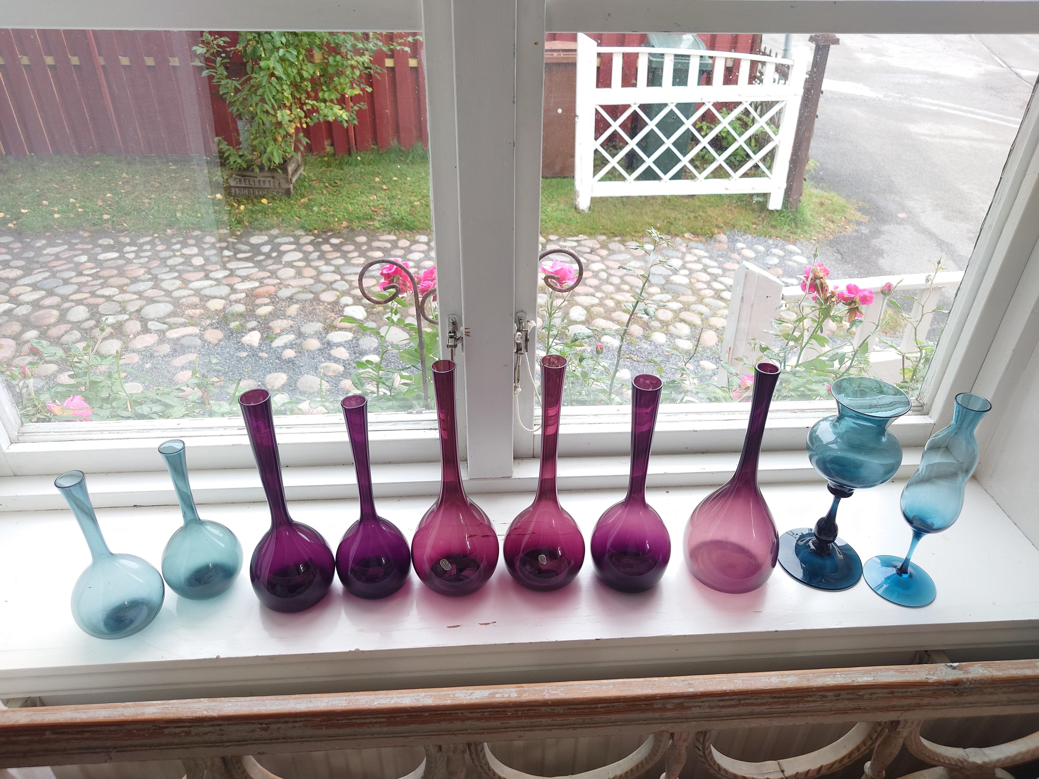 A nice collections of ten colored glass vases.
Six purple vases the highest is 27cm, lowest 23cm
Four turquoise /blue vases the highest 24cm,lowest 19cm.
One of the purple base has a small  chip at the top.
Nothing that disturb the overall
