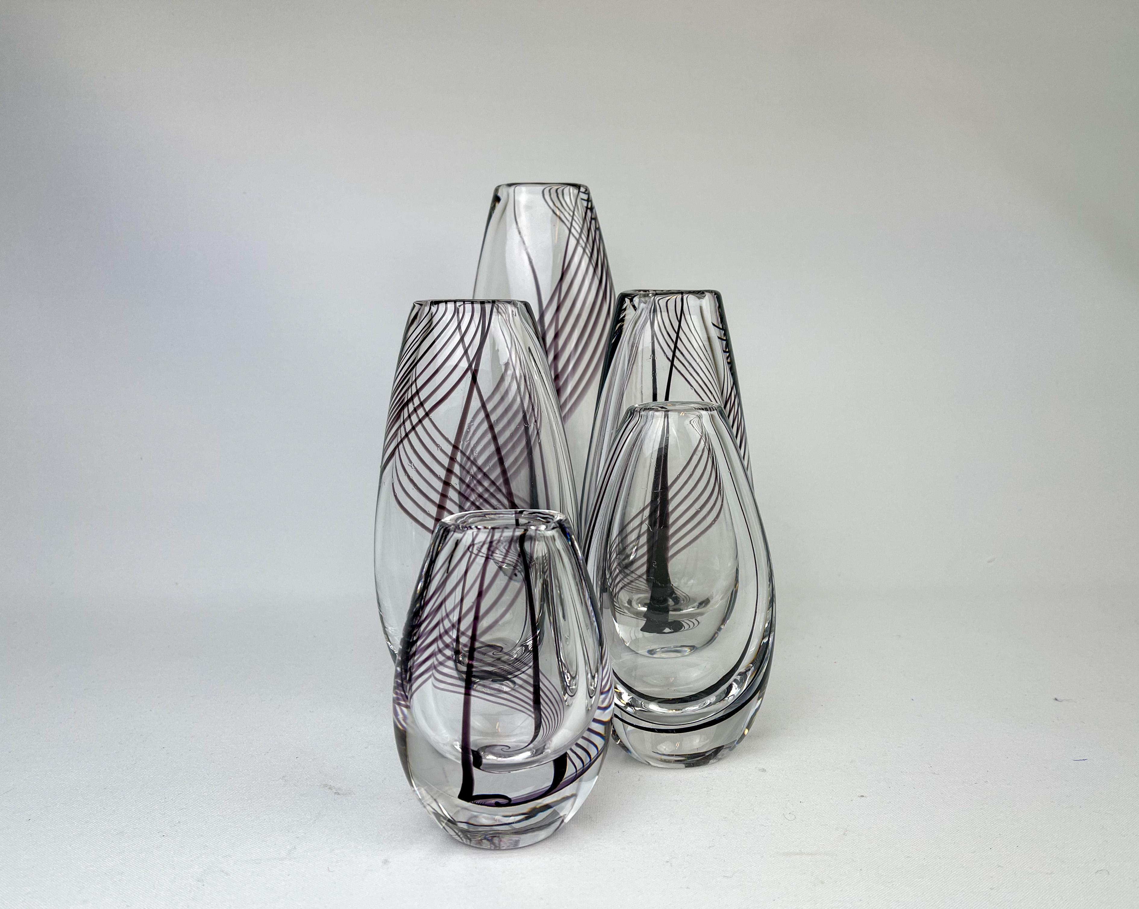 Kollektion von 5 Vasen aus Kunstglas, entworfen von Vicke Lindstrand für Kosta Sweden. Sie haben violette und schwarze Wirbellinien im Inneren des Glases. 

Schöner Zustand mit einigen Kratzern.

Dimension: 
H 23 / B 11 / T 7 cm 
H 18 / B 9 /D