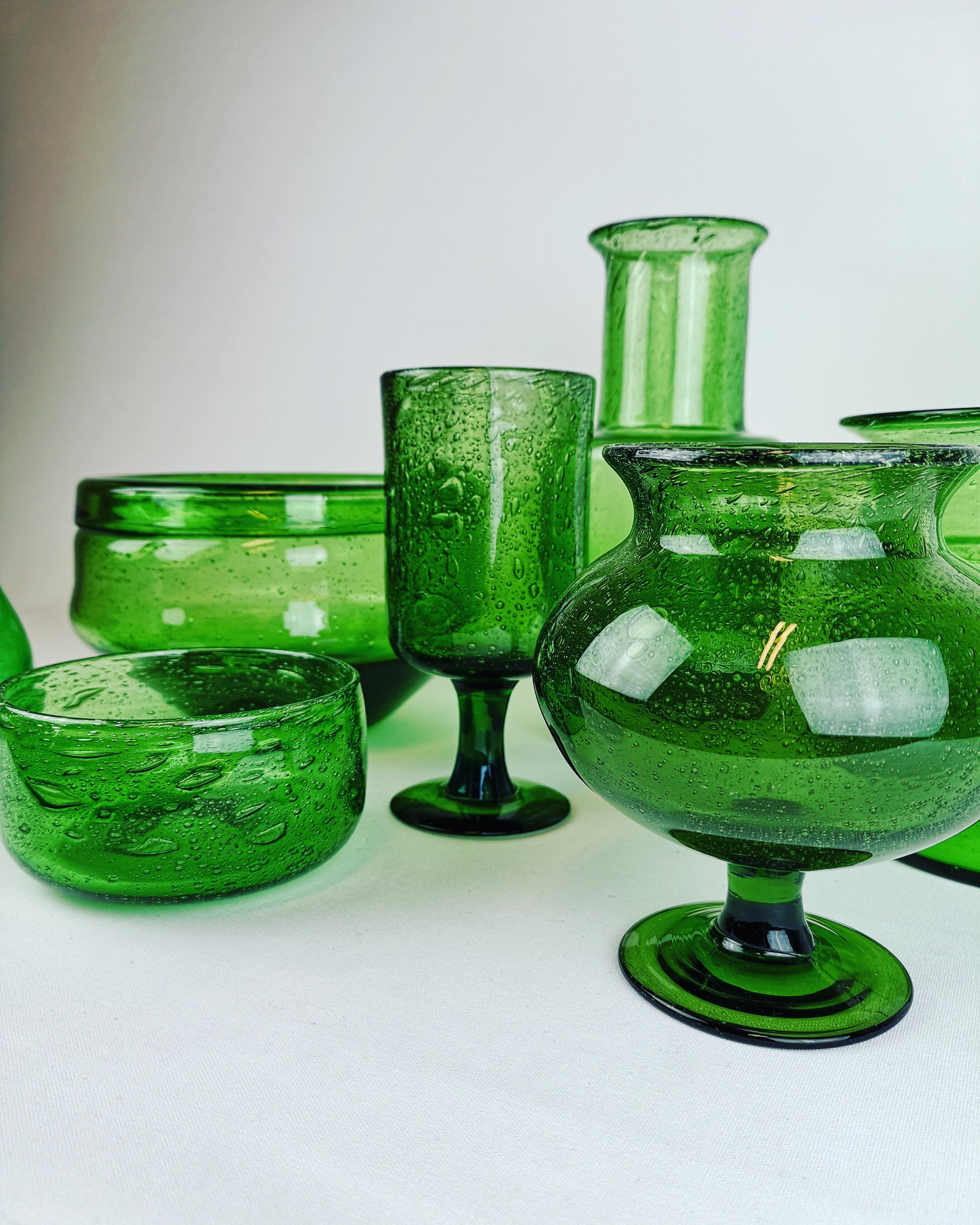 Wonderful collaboration with seven different green art glasses made in Sweden at Kosta Boda and designed by Erik Höglund. 
They are in very good condition and they are all signed. 

Biggest Measures 20 cm diameter and the tallest measures 24