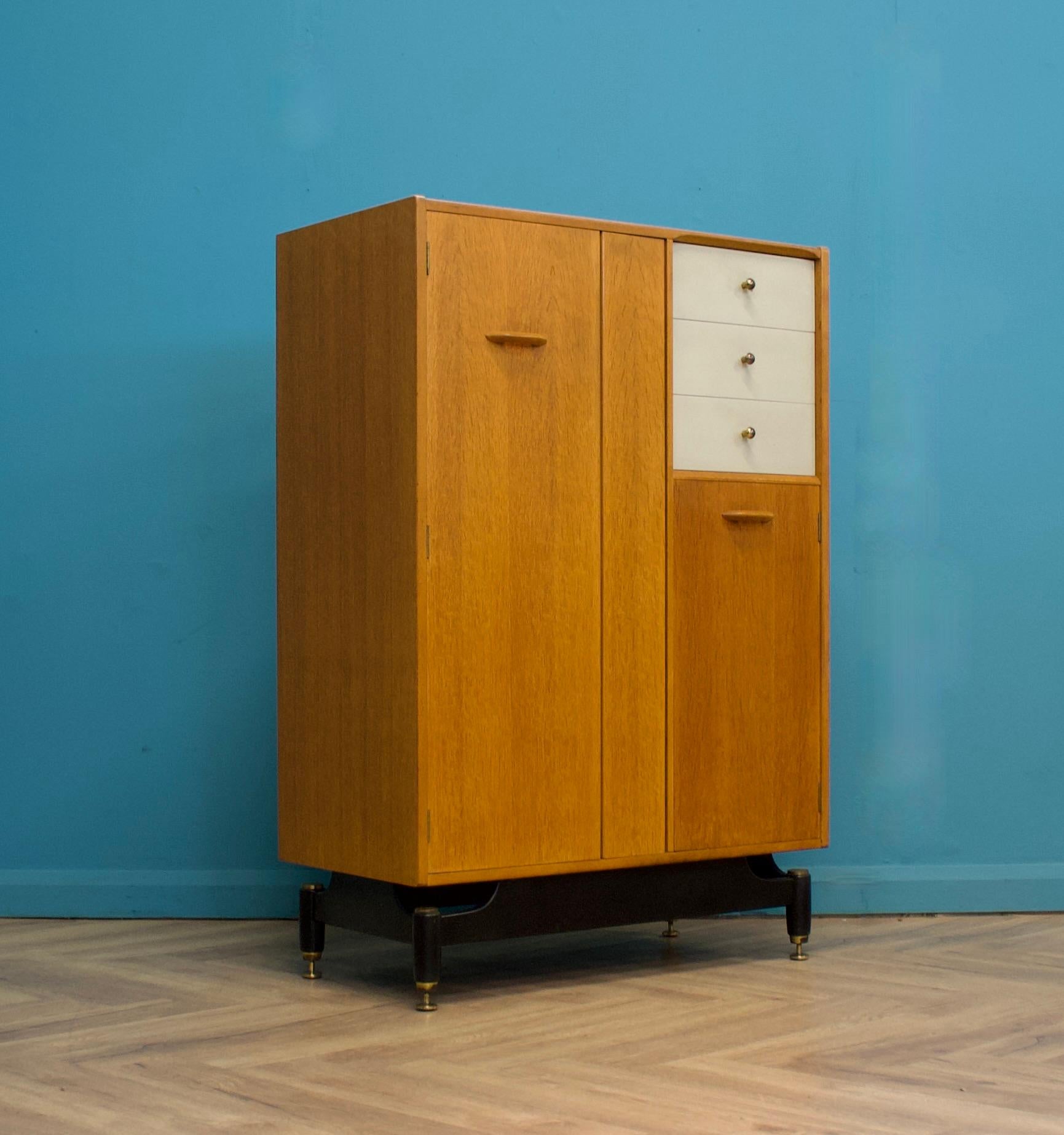 Armoire compacte moderne du milieu du siècle (Compactum).
Fabriqué par G-Plan au Royaume-Uni. 
Comprend une barre de suspension coulissante dans l'armoire de gauche, une étagère dans l'armoire inférieure de droite et 3 tiroirs, dont l'un est doté