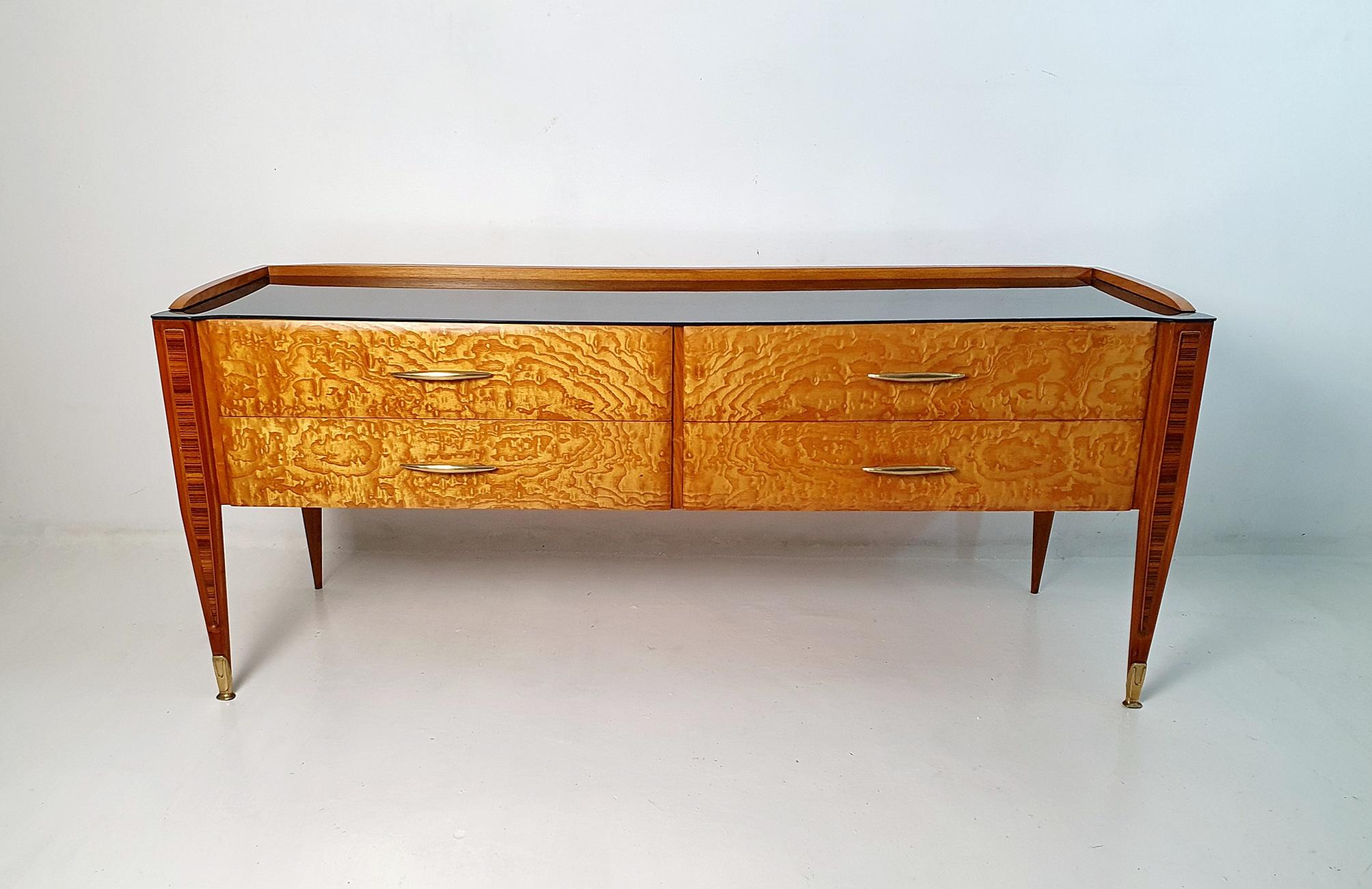 Italian designer Vittorio Dassi's midcentury credenza is a true work of art. The piece features four beveled drawers, carefully crafted from maple and walnut root, that are embellished with a striking marquetry inlay on the sculptural legs. The
