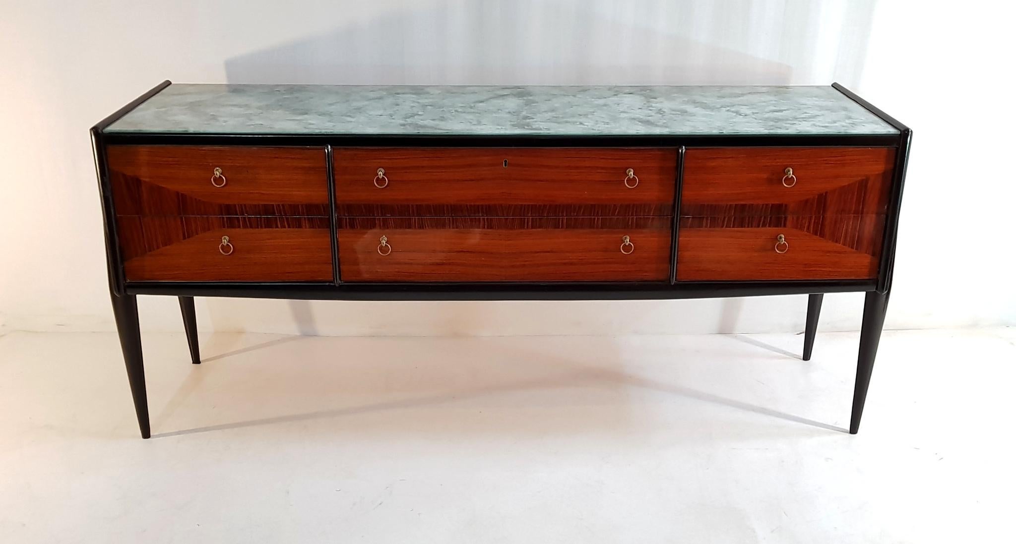 The credenza has six drawers with an intricate marquetry design in teak in a high gloss finish and with a top in glass made to imitate stone. In excellent restored condition and comes with the original key.