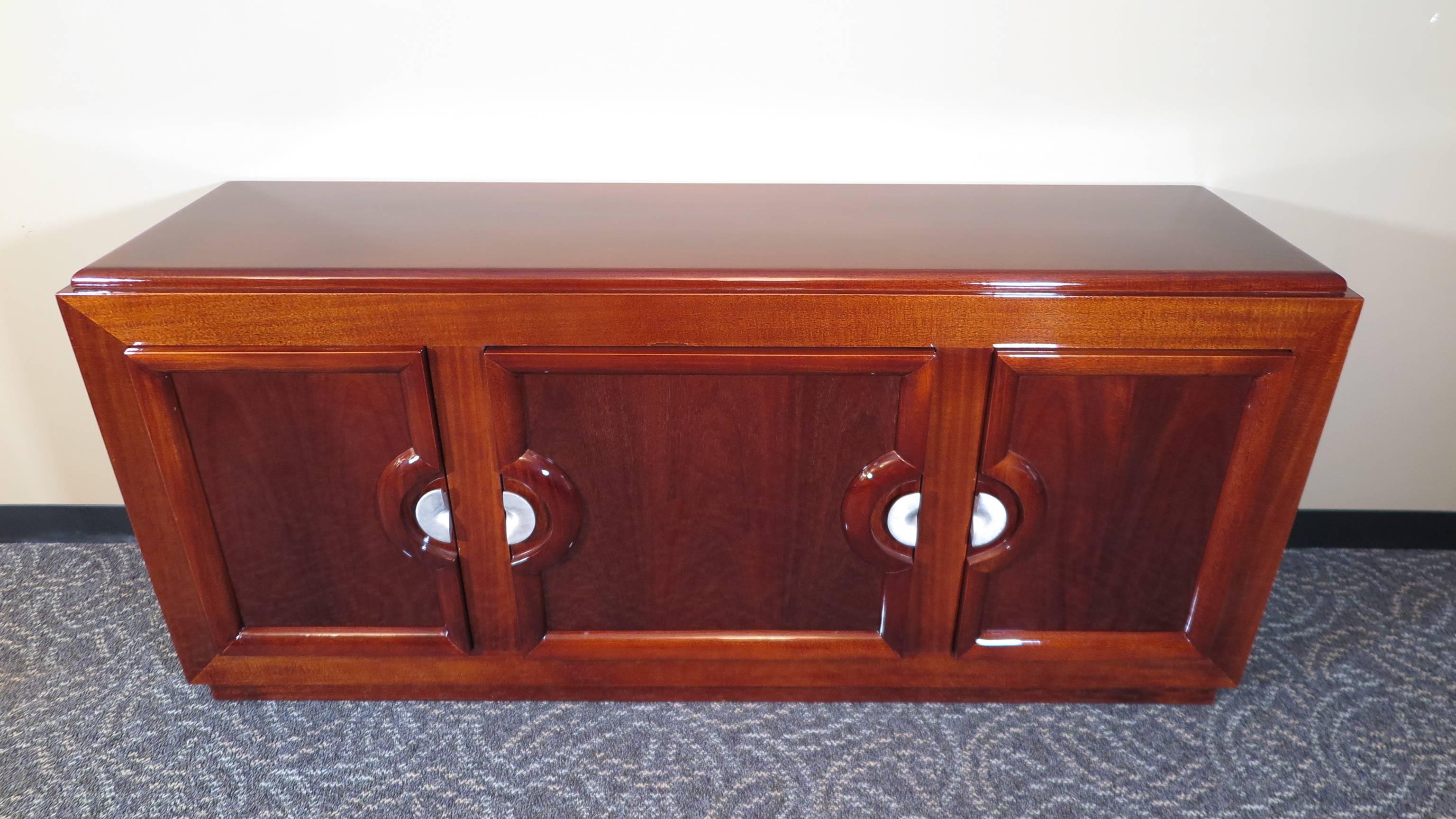 Midcentury mahogany sideboard credenza in the style of Paul Laszlo. Having three storage areas with a serving drawer in the middle. very Very good condition.  