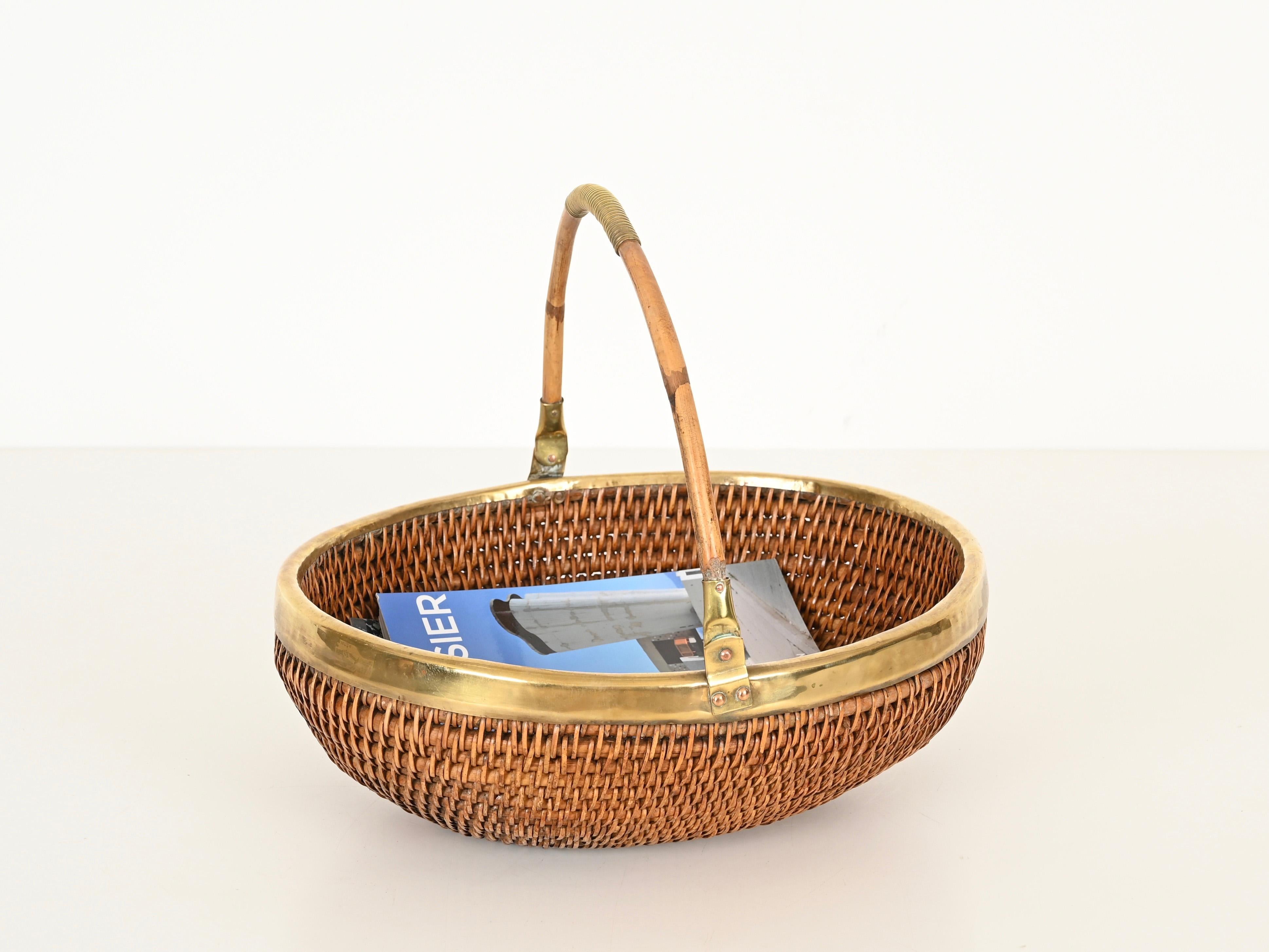 Wonderful Italian mid-century centerpiece, magazine rack or decorative bowl handcrafted in curved rattan, handwoven wicker and brass. This stunning piece was designed in Italy during the 1970s clearly in the style of Gabriella Crespi.

In fabulous