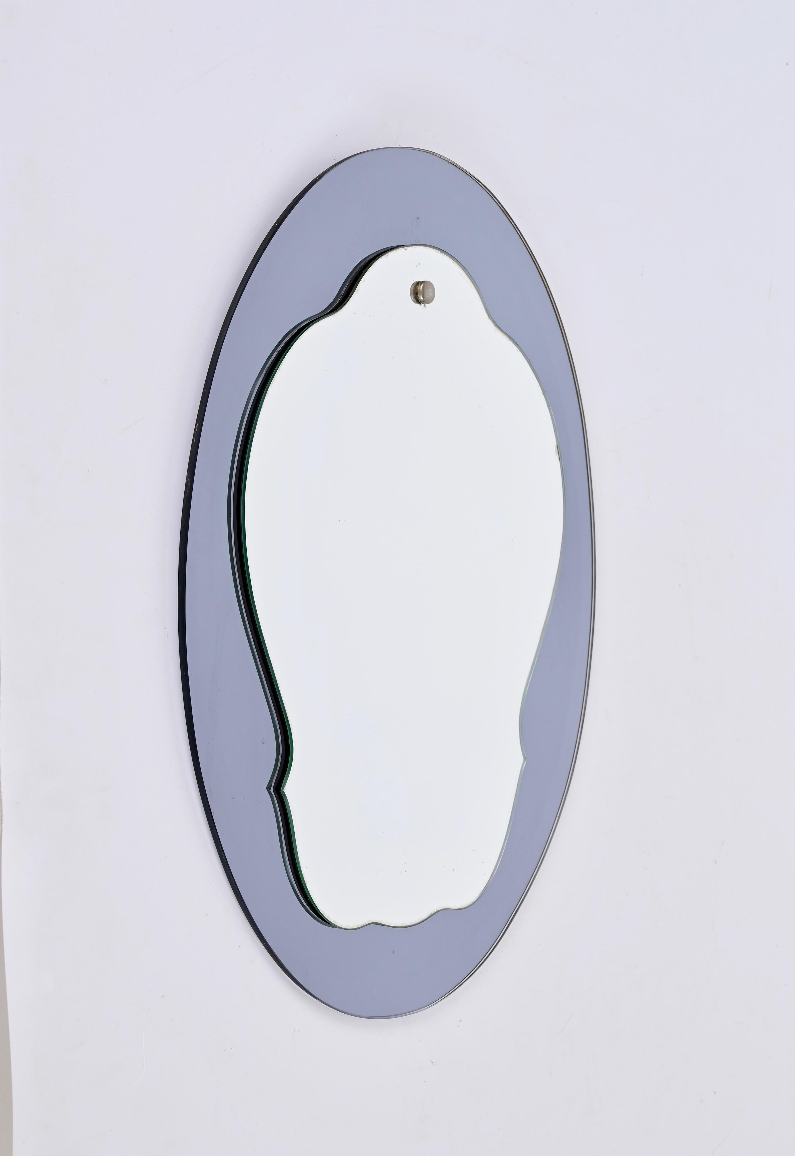 Superbe miroir ovale à deux niveaux du milieu du siècle dernier avec un cadre en verre bleu-gris. Cristal Arte a probablement conçu cette pièce fantastique qui a été produite en Italie dans les années 1960.

Grâce à son design et à ses lignes