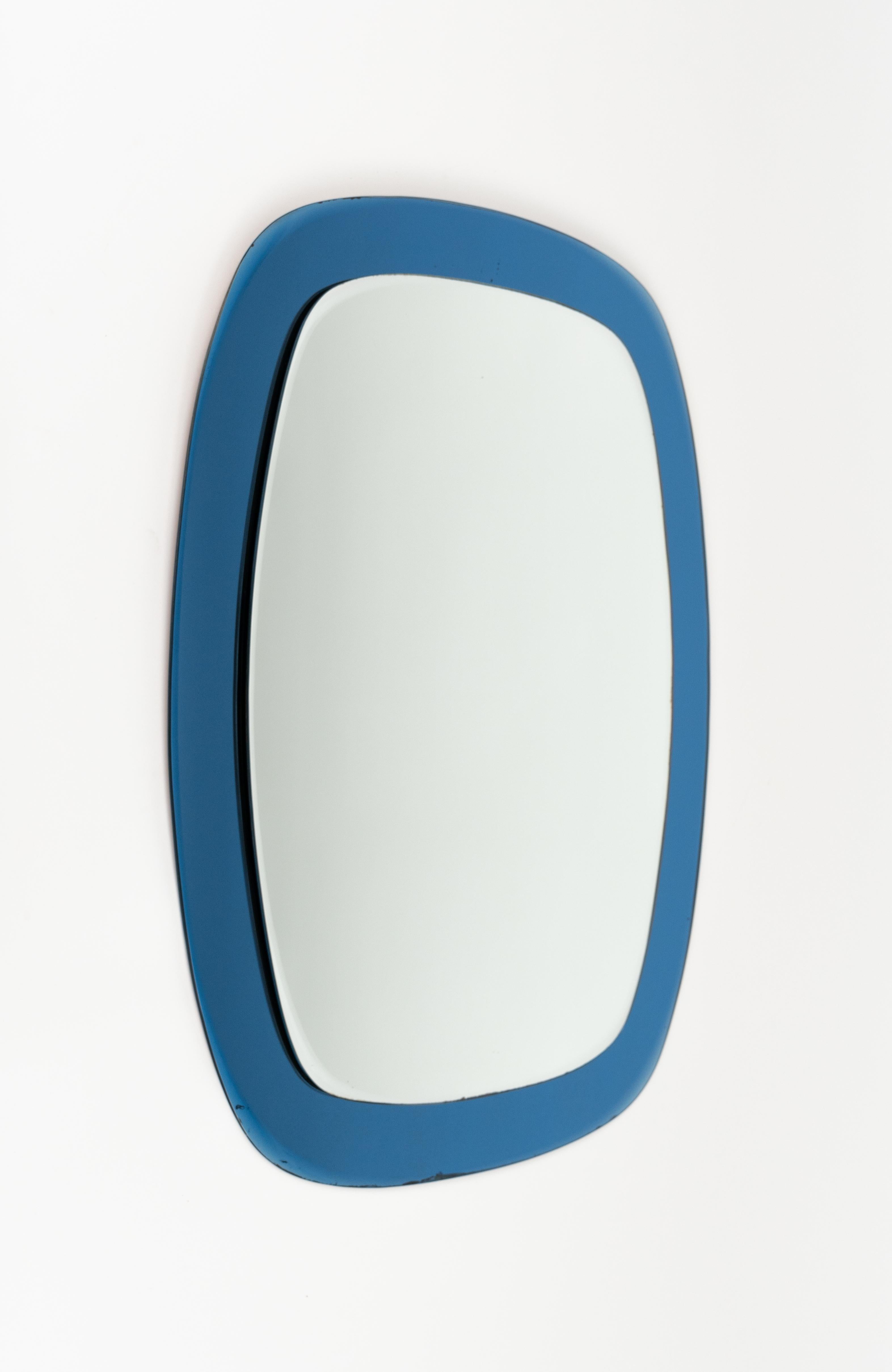 Midcentury beautiful double-level oval wall mirror with a smoked blue glass frame attributed to Cristal Art.  

Made in Italy in the 1960s.

The mirror, original of the period, shows small signs of discolouration.