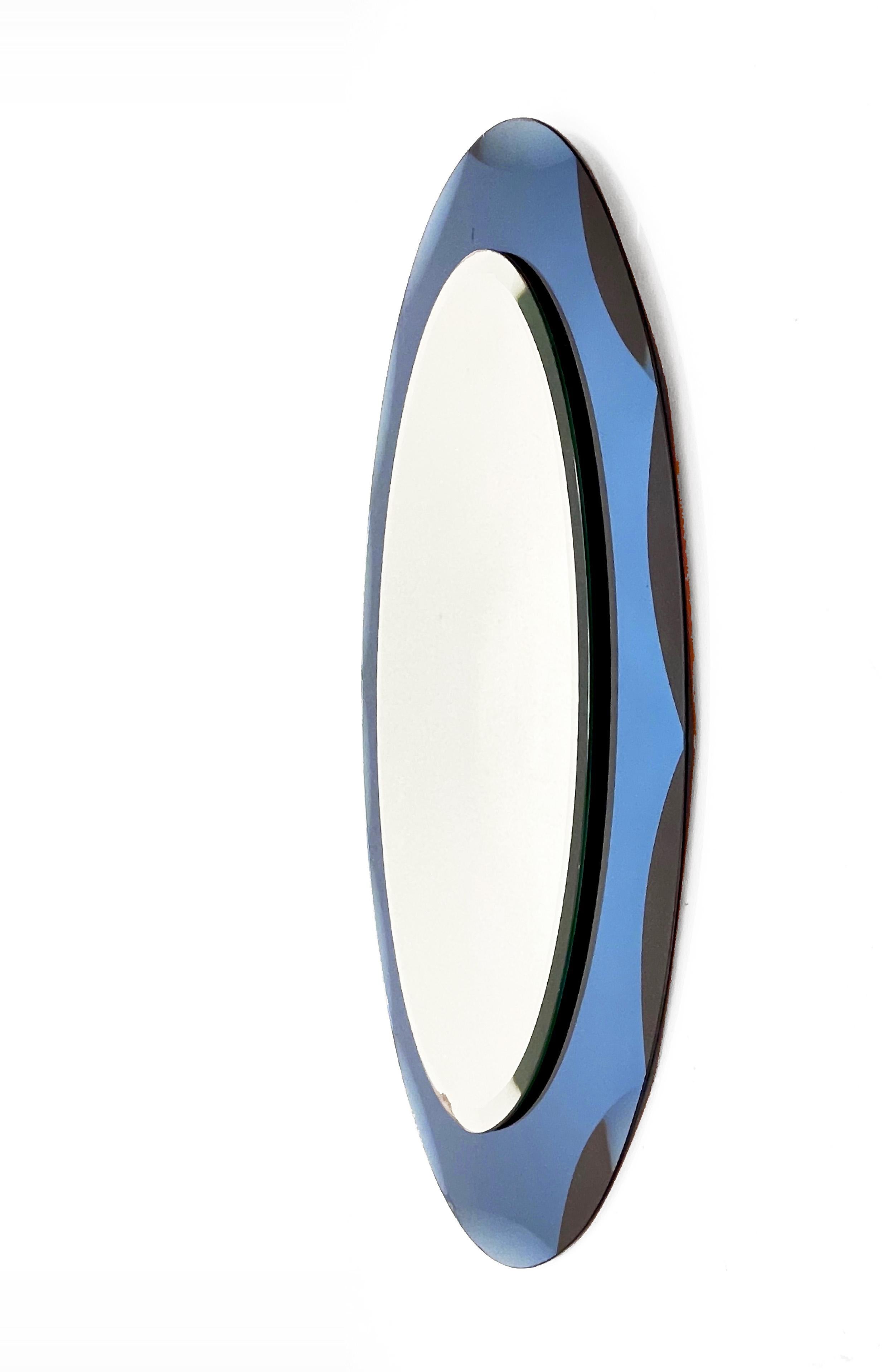 Beautiful midcentury oval mirror with blue graven frame. This Italian mirror is in the style of Cristal Arte and was designed in Italy during the 1960s.

This piece is an example of excellent Italian manufacture with a double mirror layer.

The