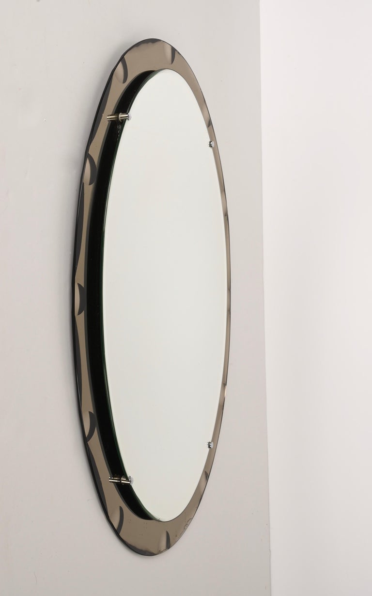Amazing mid-century oval mirror with bronzed graven frame. This mirror was designed in Italy in the style of Cristal Arte during the 1960s.

This piece is an example of excellent Italian craftsmanship with a double mirror layer. The external frame
