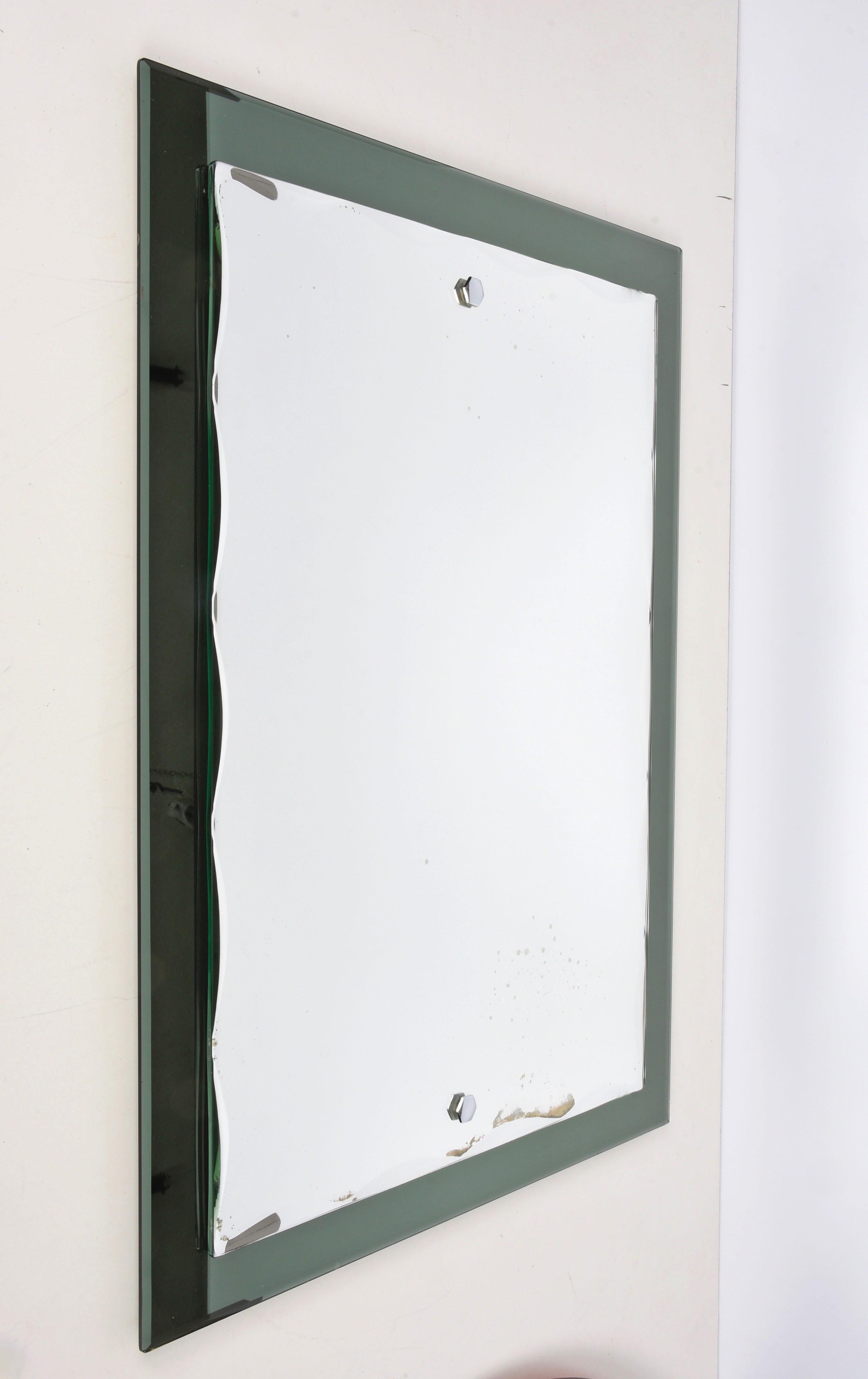 Beautiful midcentury mirror with olive green glass frame and carved rectangular mirror. This Italian mirror was designed in the style of Cristal Arte and was made in Italy during the 1960s.

This piece is an example of excellent Italian