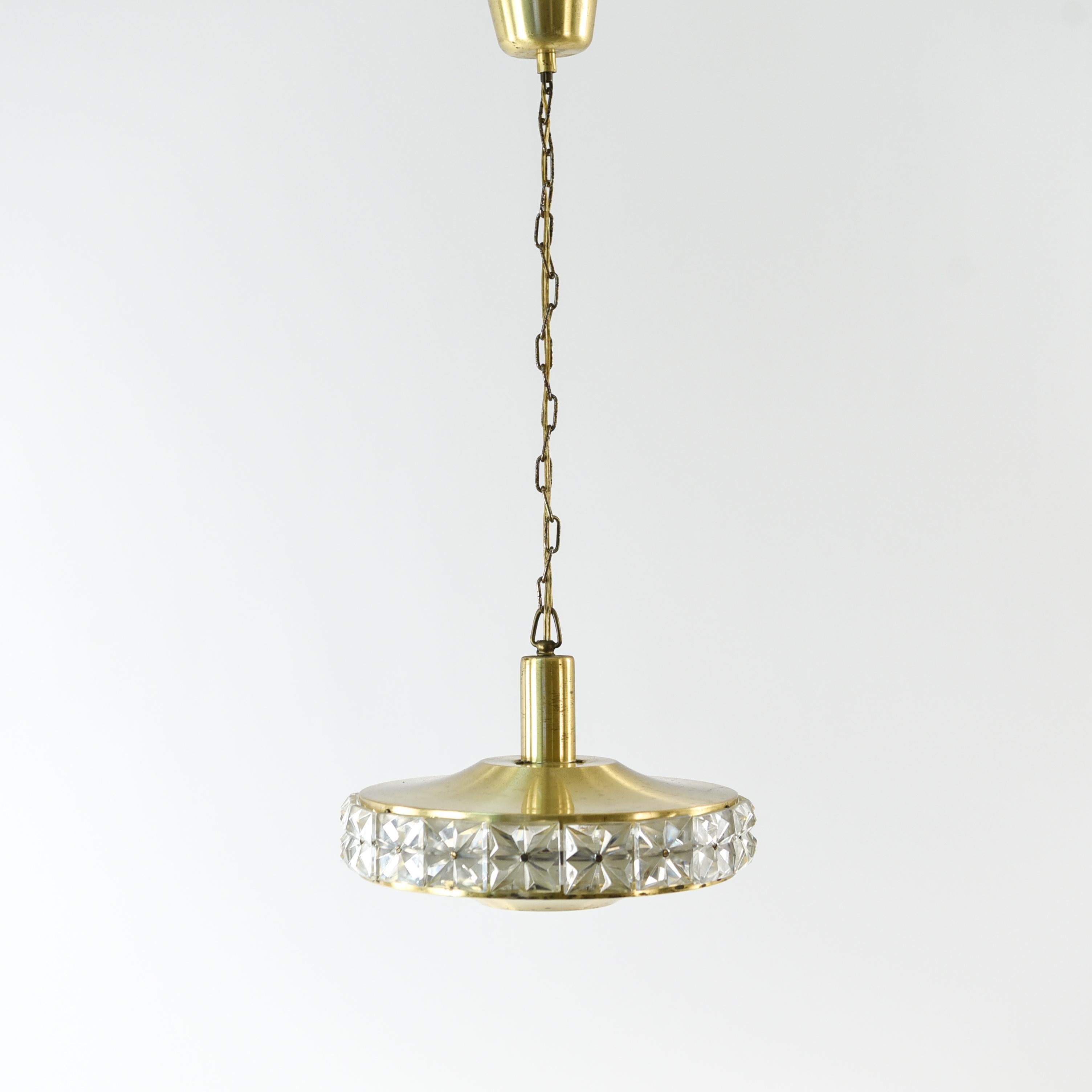 This midcentury crystal and brass pendant chandelier was manufactured and designed by Vitrika in Denmark in the 1960s. Featuring cut crystal panels in a brass framework.