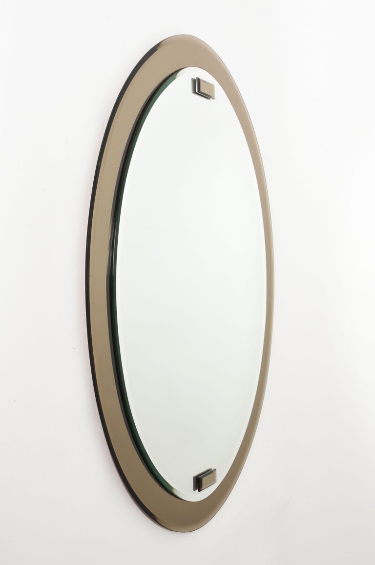 Double-layered single and large midcentury wall mirror. It was produced in Italy during the 1960s.

It is very rare in that it has two layers of mirrors, a crystal one and a gray one in the ground, with frame functionality.

A wonderful