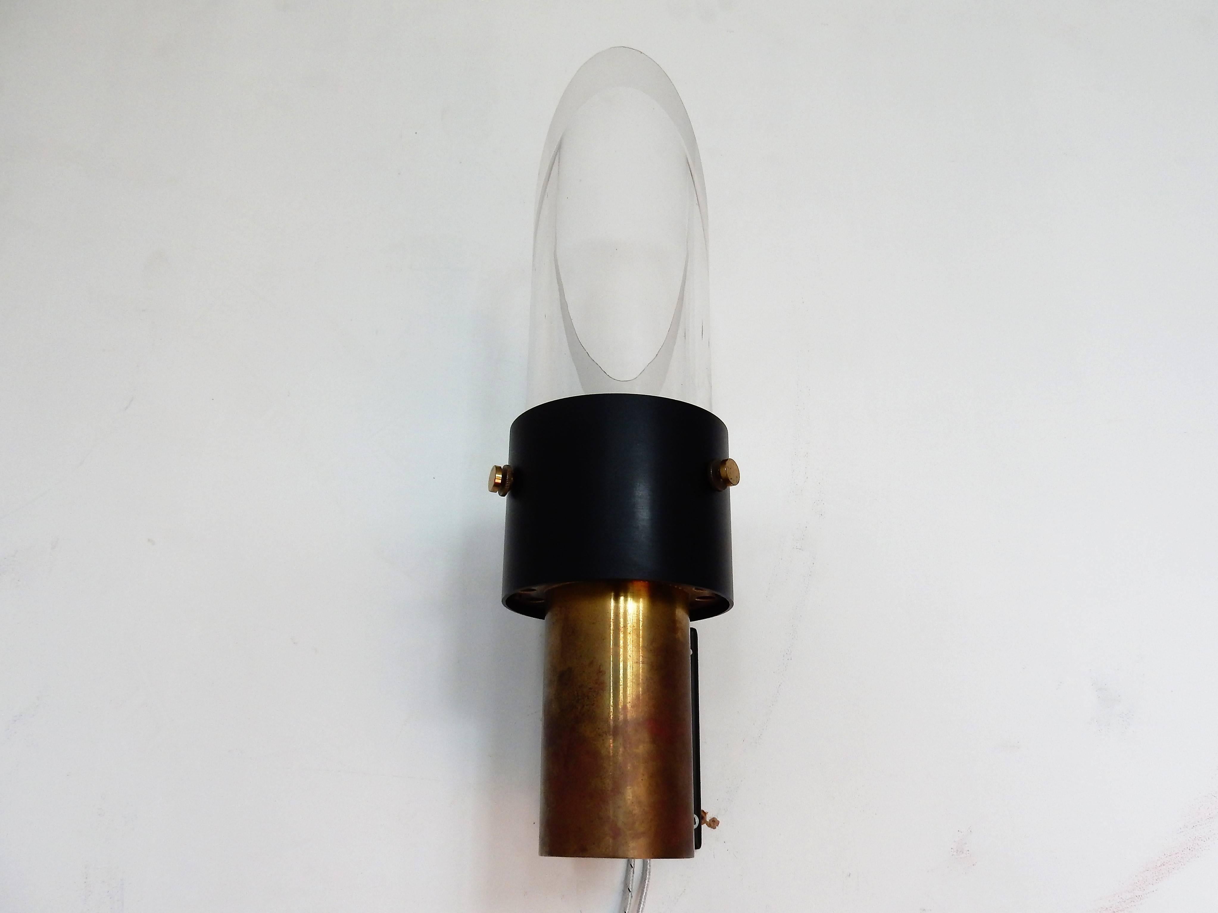 This midcentury wall lamp, model 'Saga' was made by Lyfa in Denmark in collaboration with the Swedish company Orrefors. It is made of metal, brass and crystal glass. The wall lamp can be placed upside down and vice versa. It is in a very good