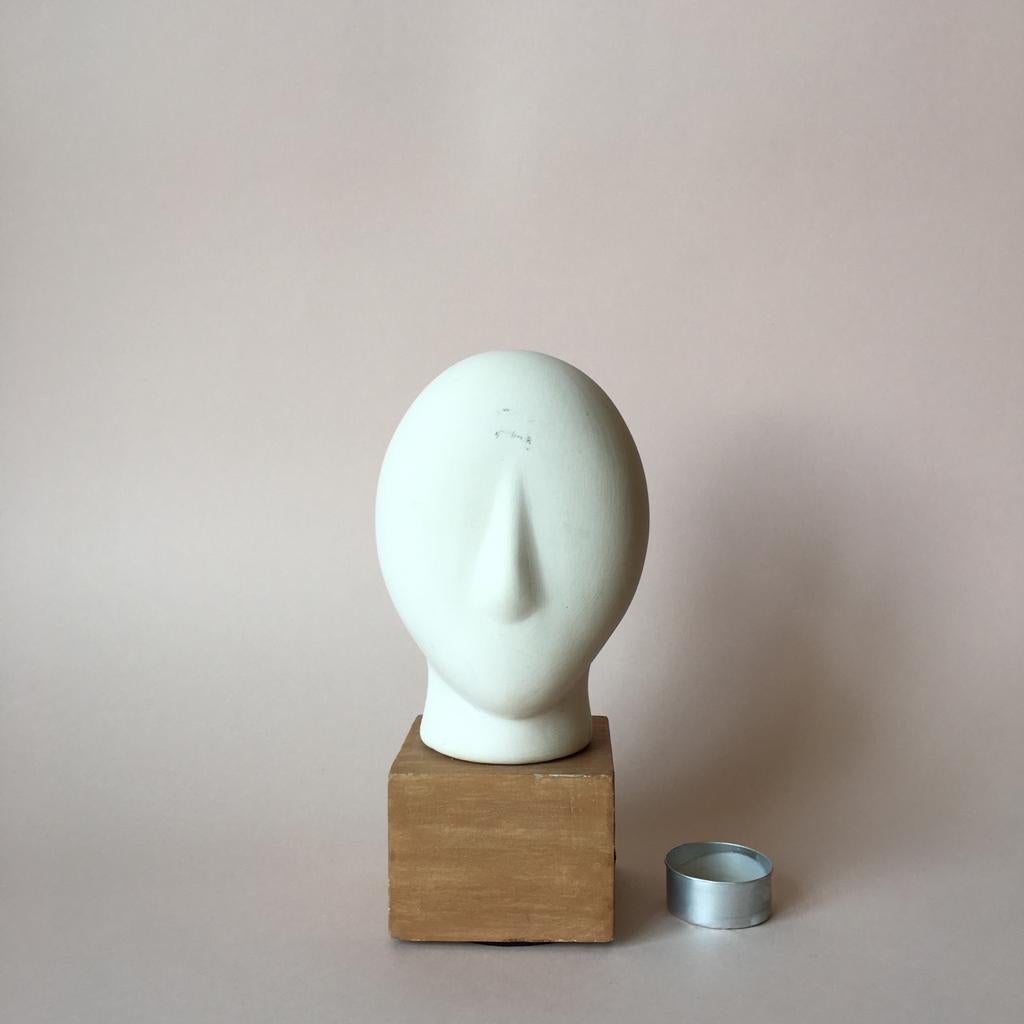 Minimalist head sculpture made of matte clay on a faux wood base. The head color is off-white and it is very pleasant to touch.

Measures: H 20 cm
D(head) 9.5 cm.